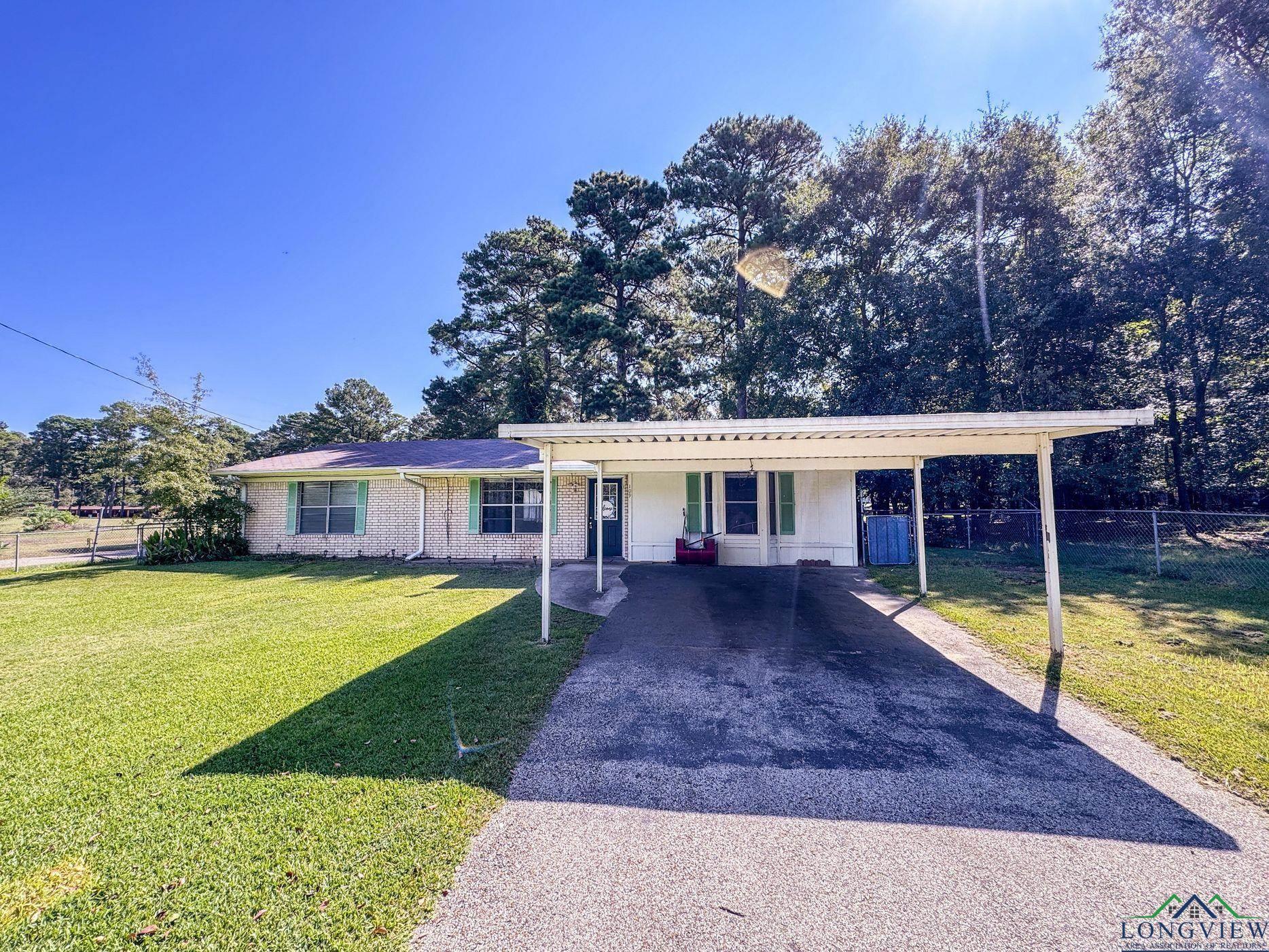 Image 0: Single story home with asphalt driveway, a carport, brick siding, and covered porch, Front Of Structure
