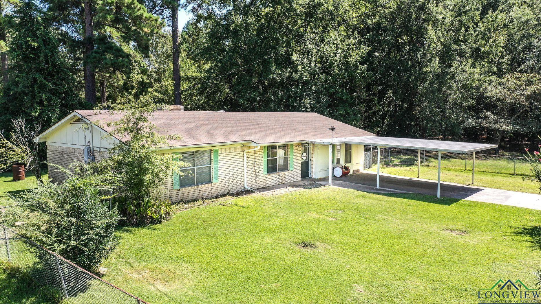 Image 1: Ranch-style house with brick siding, a shingled roof, driveway, and covered porch, Front Of Structure