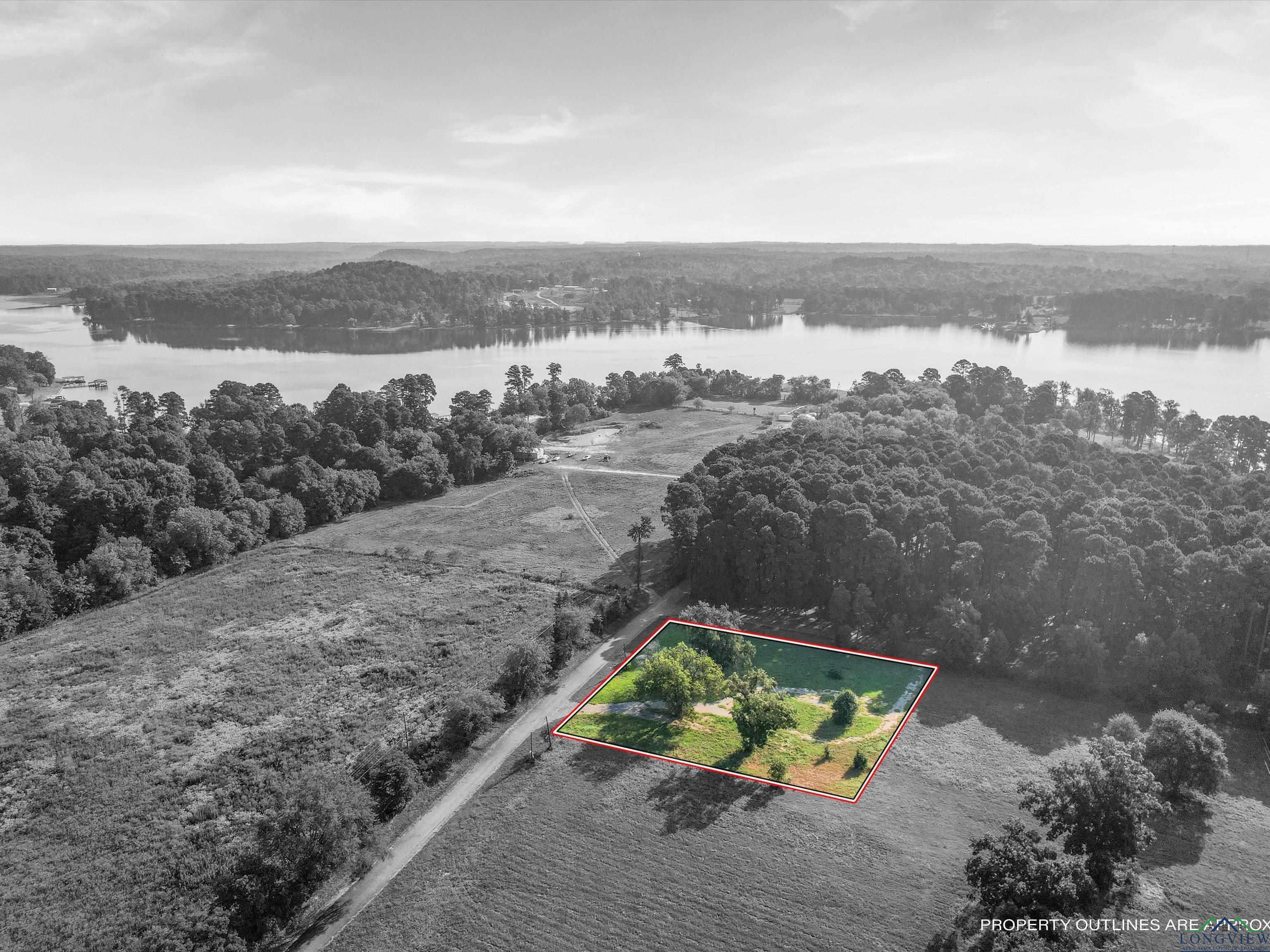 Image 1: Aerial view of property and surrounding area featuring a nearby body of water and property boundaries highlighted, Aerial View