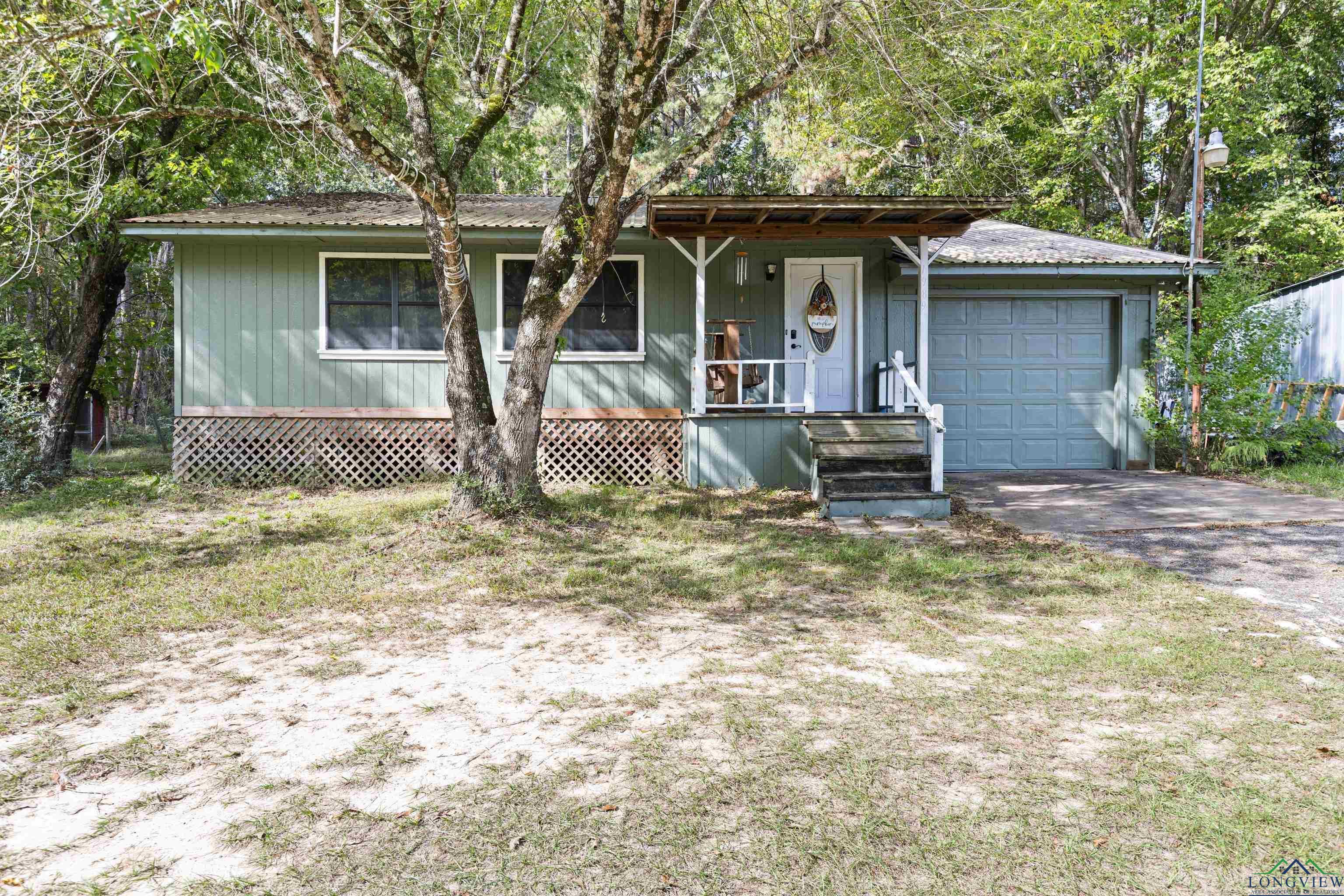 Image 0: Cottage-style home with covered porch, driveway, and a metal roof, Front of Home