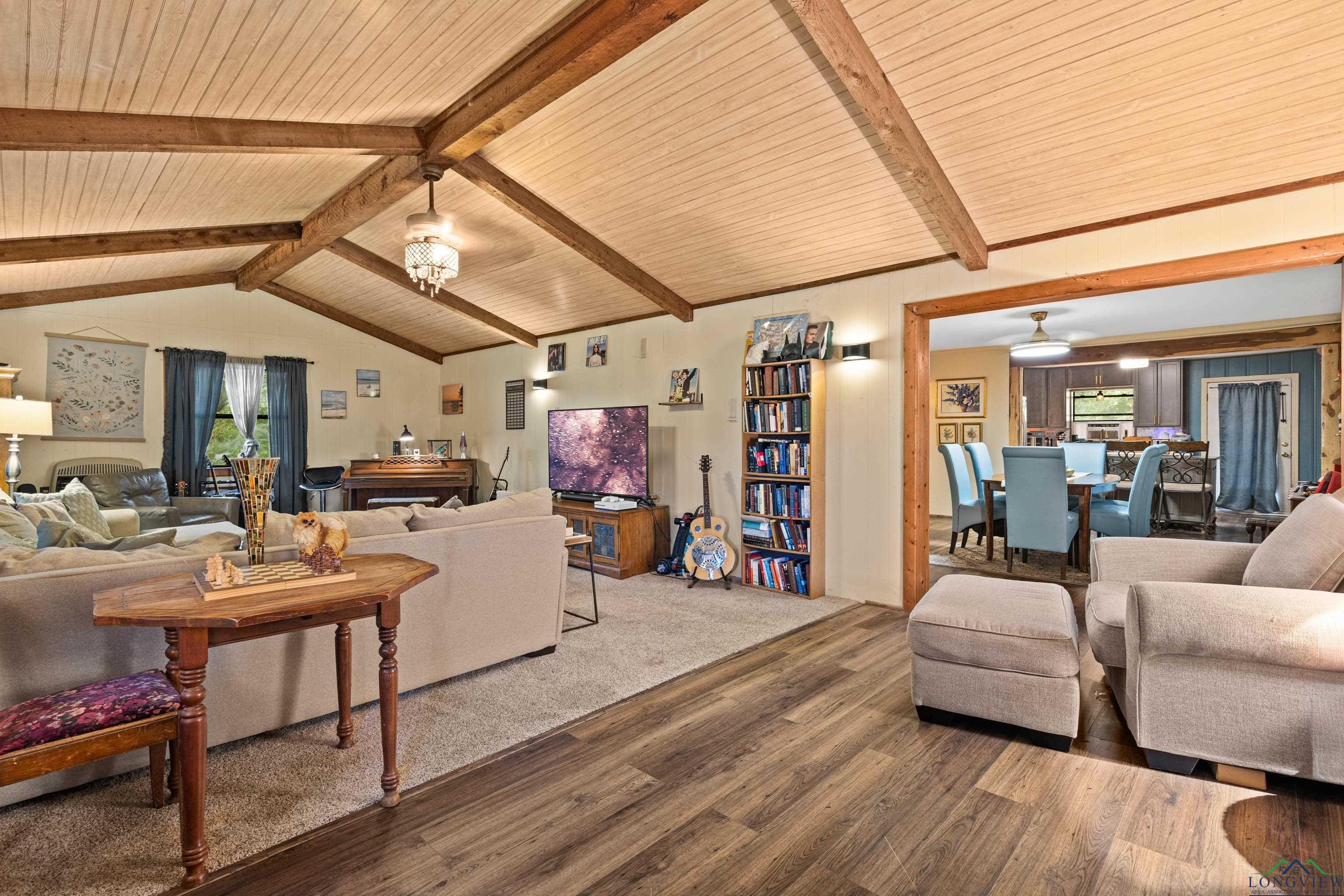 Image 3: Living area featuring wood finished floors and vaulted ceiling, Living Room