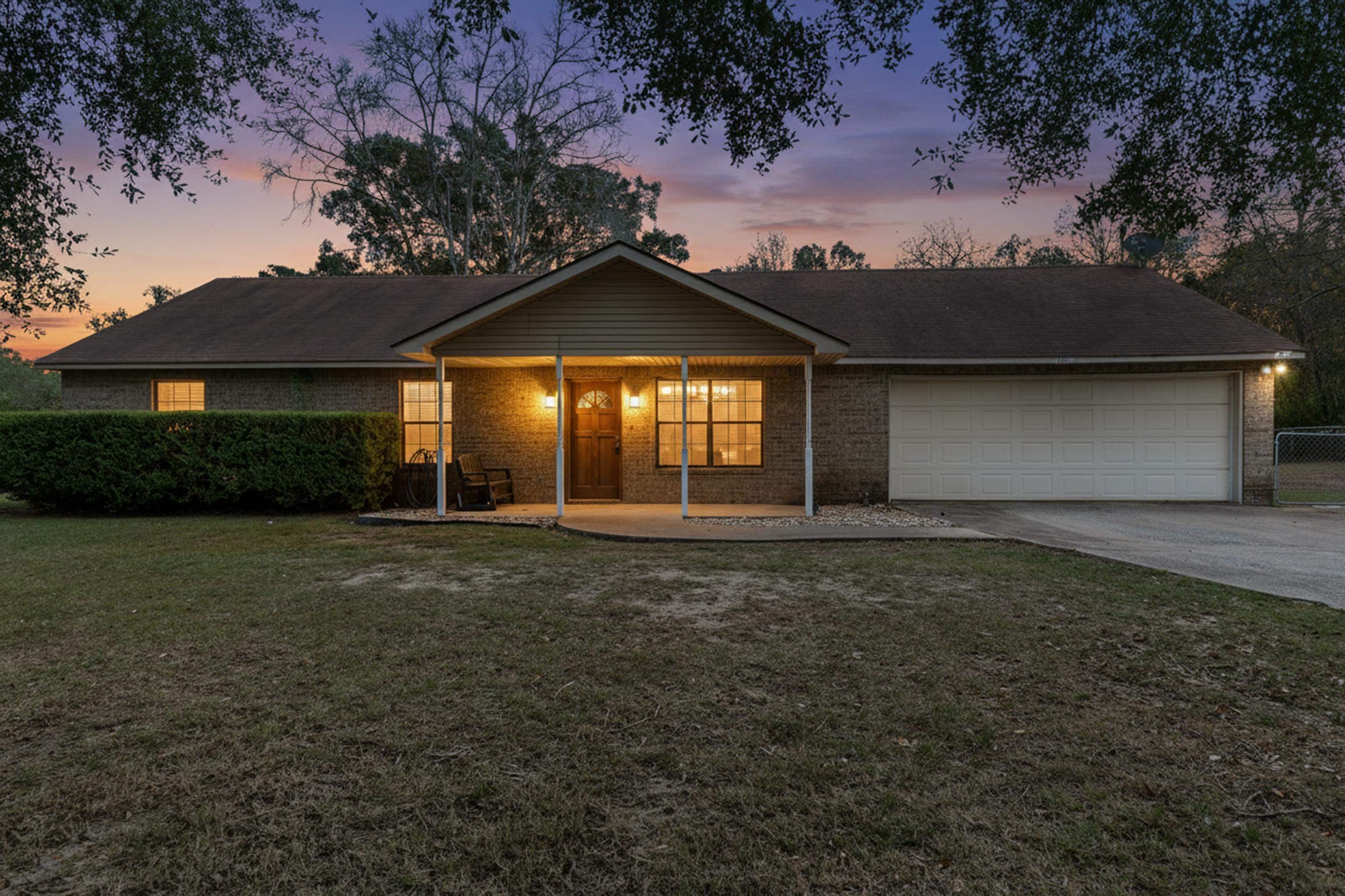 Image 0: Ranch-style house with a lawn, brick siding, driveway, a garage, and covered porch, Front Of Structure