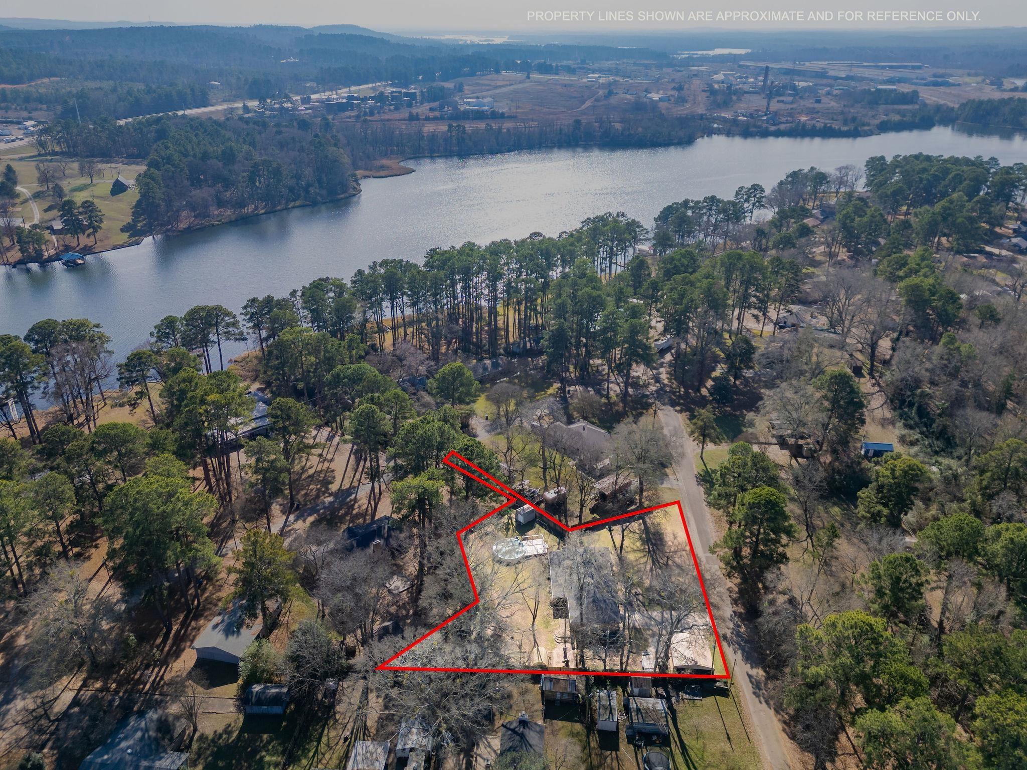 Image 1: Aerial overview of property's location with property boundaries highlighted and a nearby body of water, Aerial View