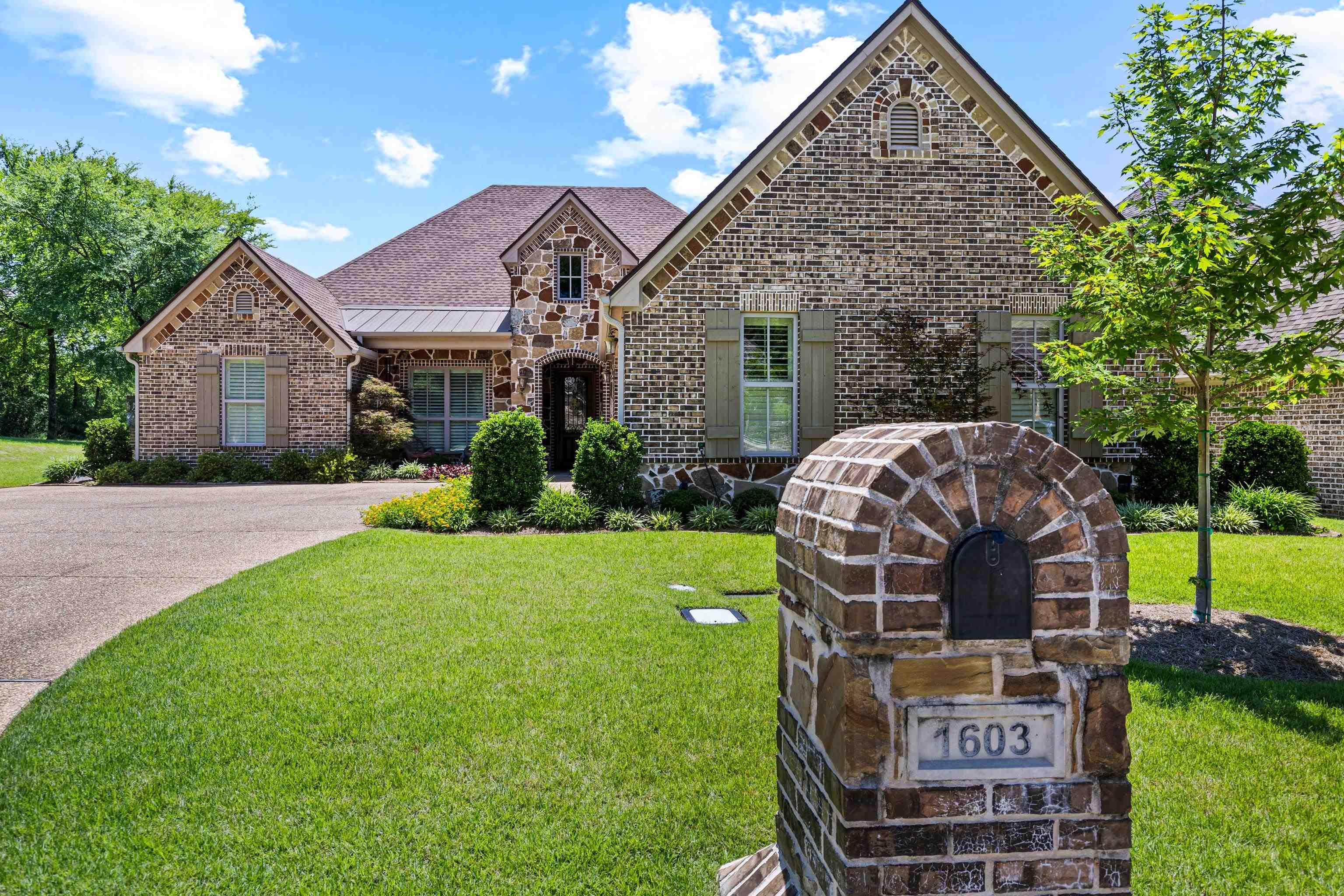 Image 0: Brick and stone exterior with arched entry, Front Of Structure