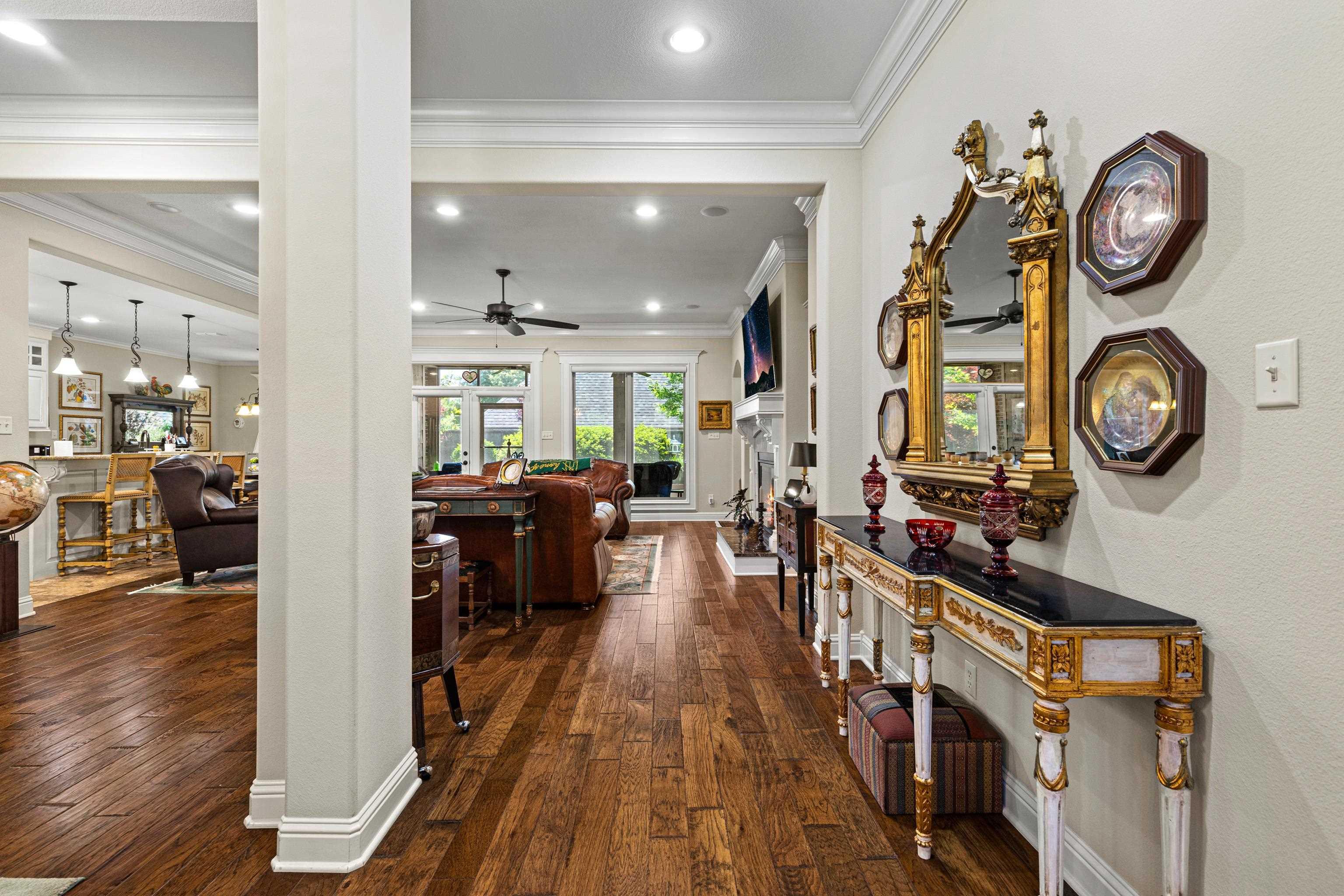 Image 2: Hallway with wood-finish flooring, crown molding, recessed lighting, and a console table with a dark top, Hallway