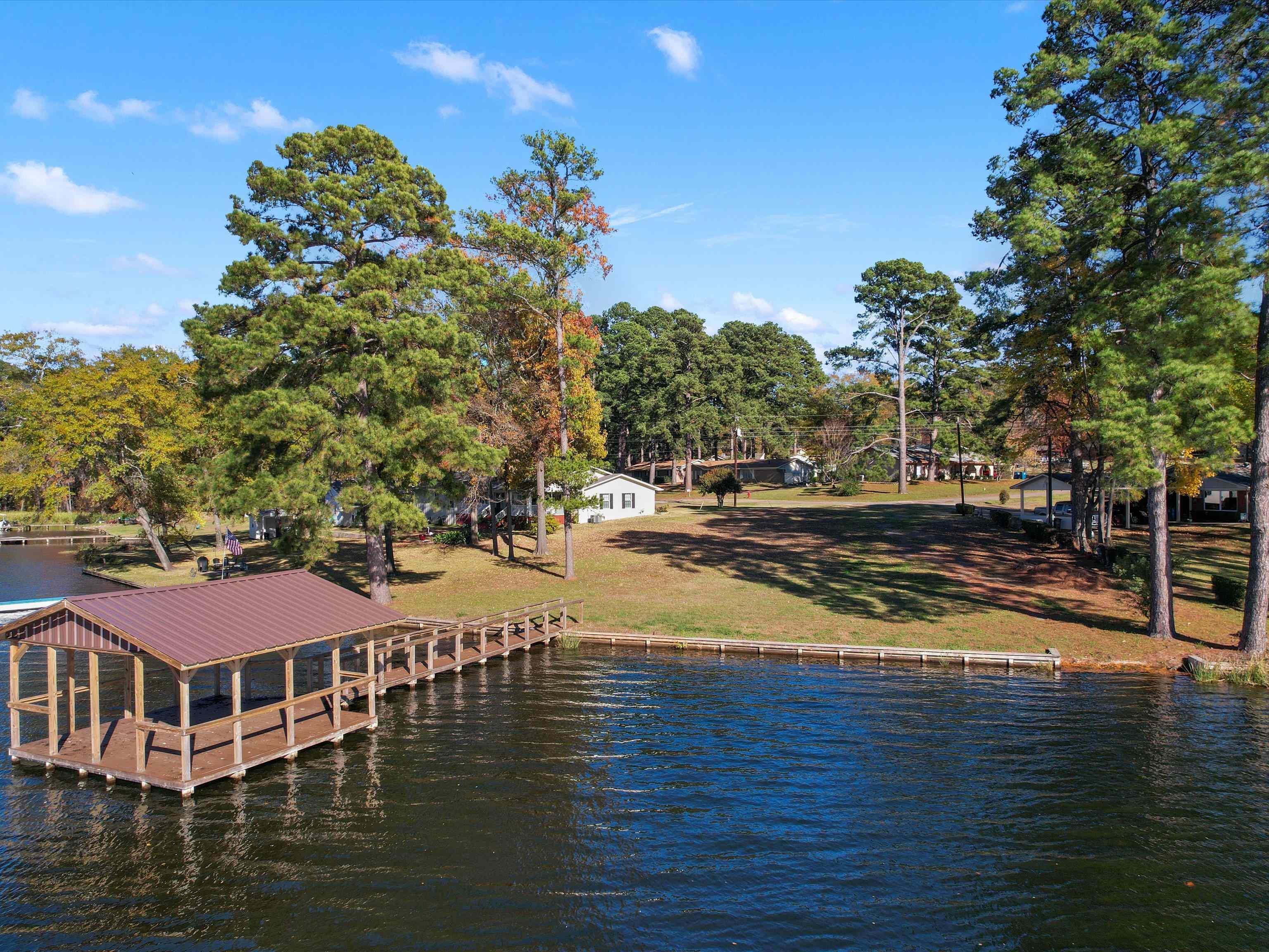 Image 0: View of dock with a yard and a water view, Dock