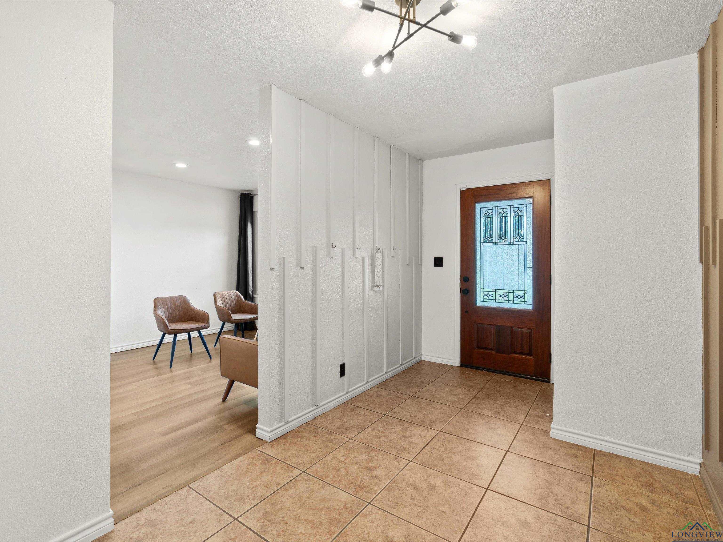 Image 3: Foyer featuring light tile patterned floors and a chandelier, Entrance Foyer