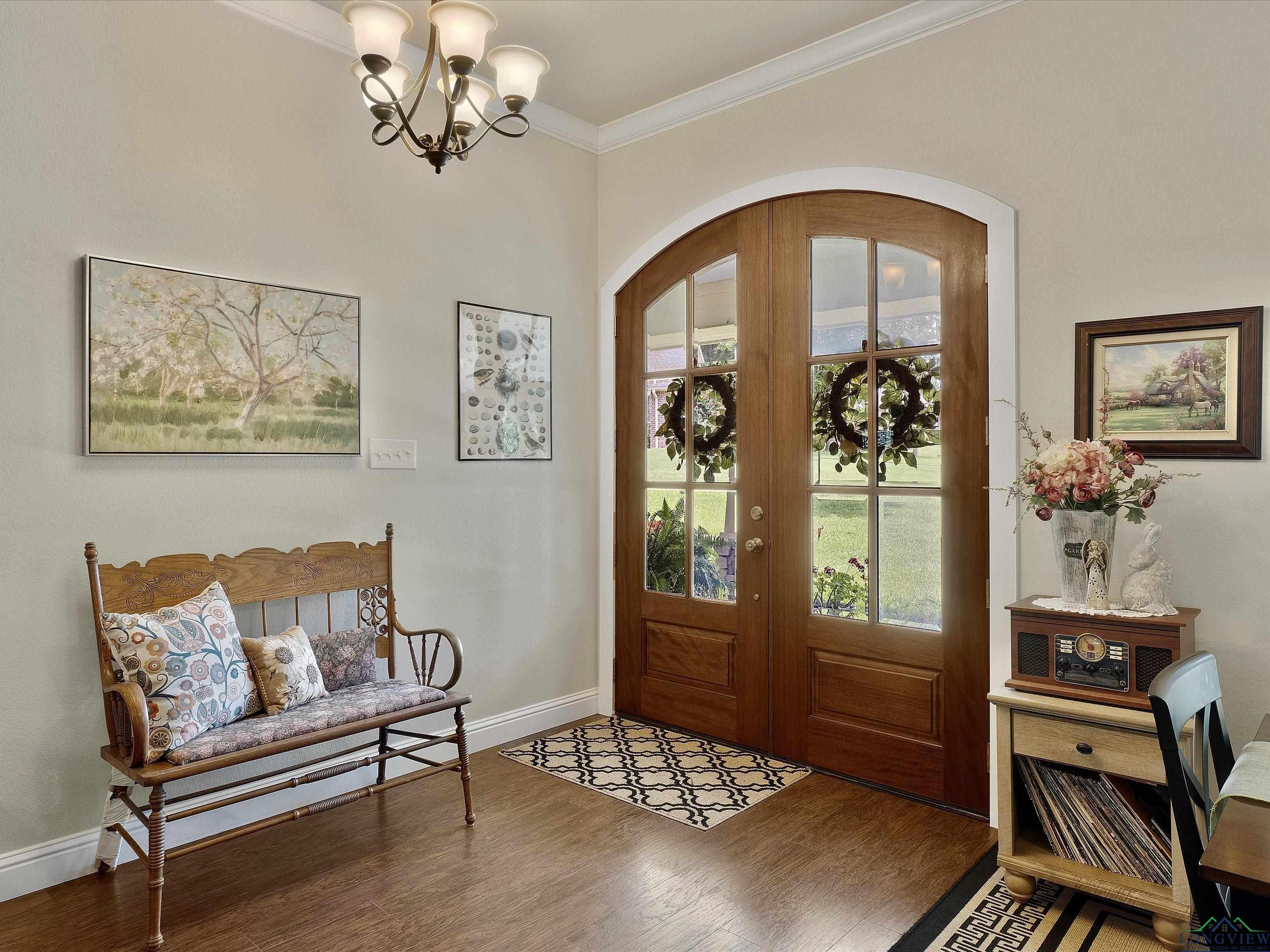 Image 3: Entryway featuring ornamental molding, a chandelier, french doors, wood finished floors, and arched walkways, Entrance Foyer