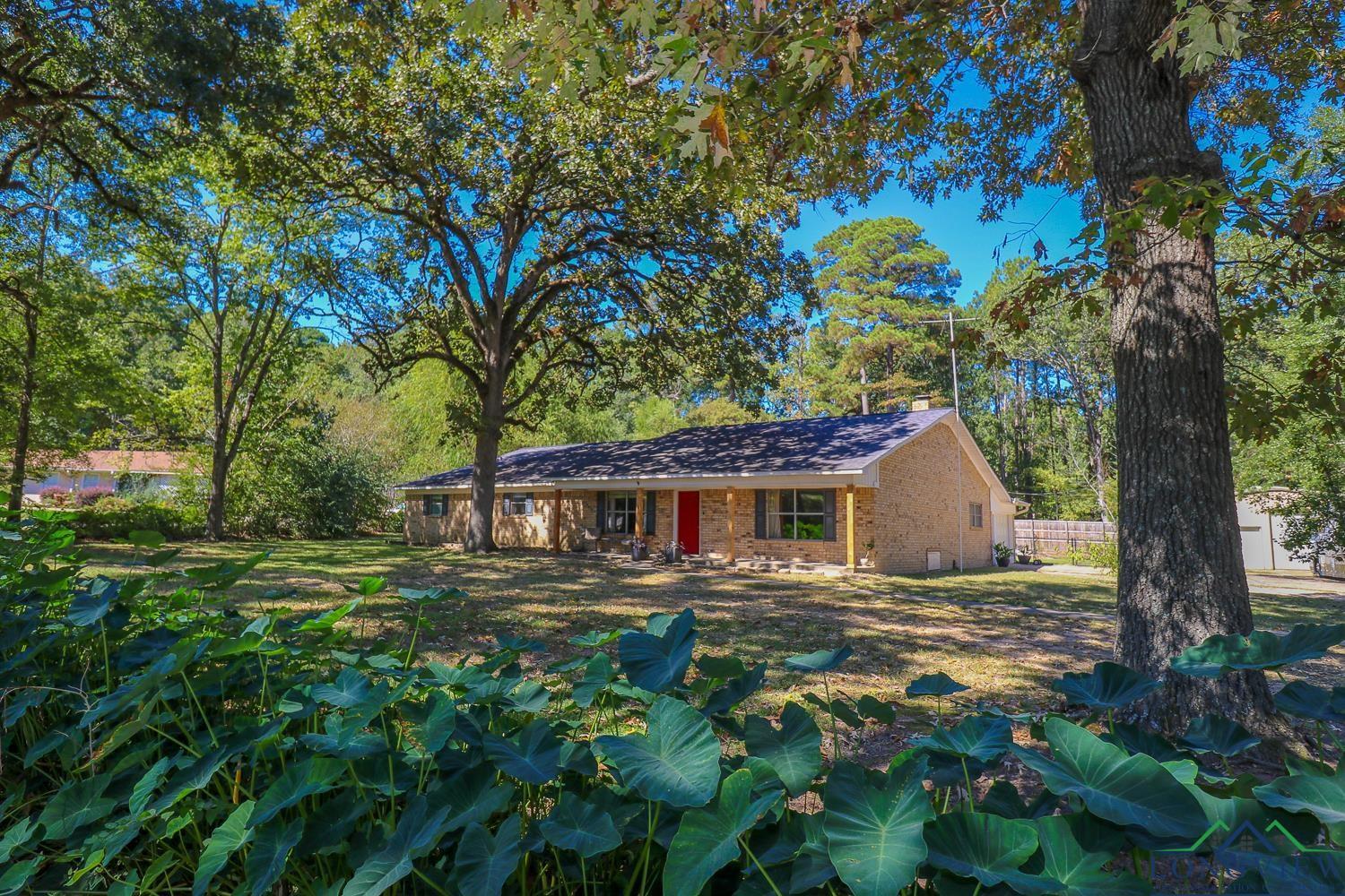 Image 2: Ranch-style house featuring brick siding and view of wooded area, Front Of Structure