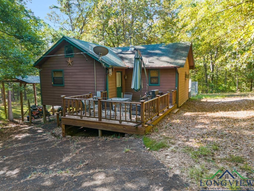Image 1: Back of house with a wooden deck and roof with shingles, Back Of Structure