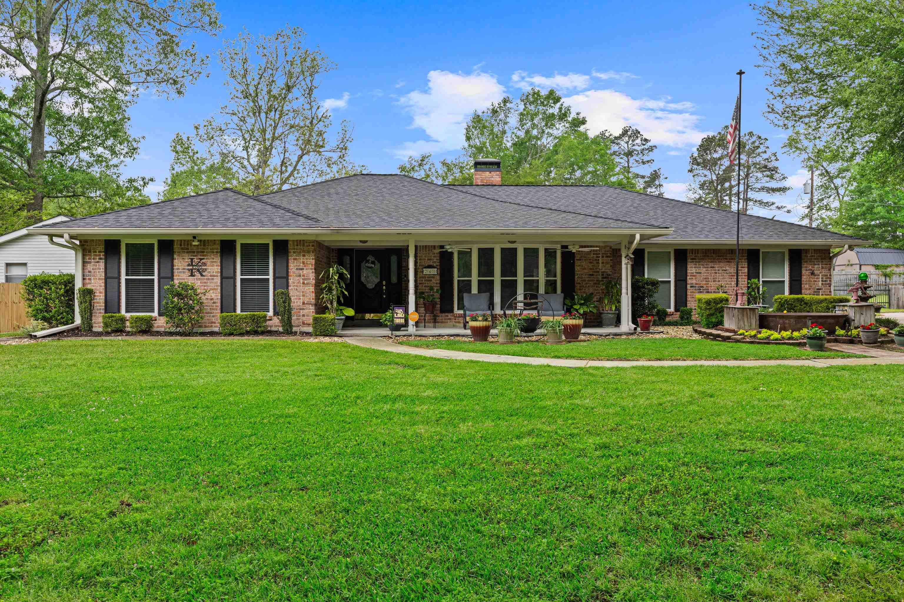 Image 0: Ranch-style home featuring a shingled roof, a chimney, brick siding, and a porch, Front Of Structure