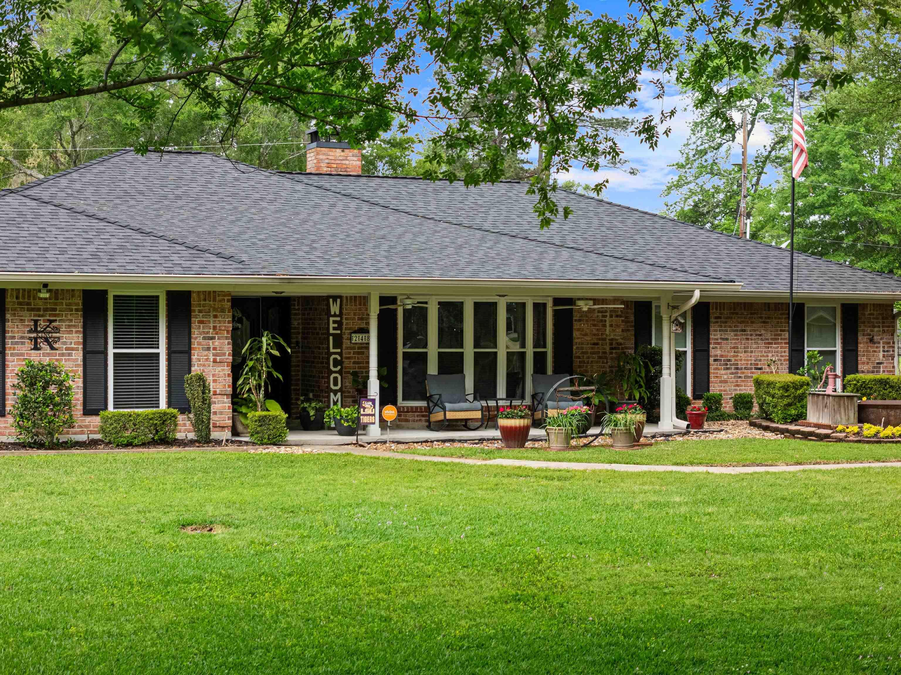 Image 2: Single story home featuring a front yard, a chimney, a shingled roof, and brick siding, Front Of Structure