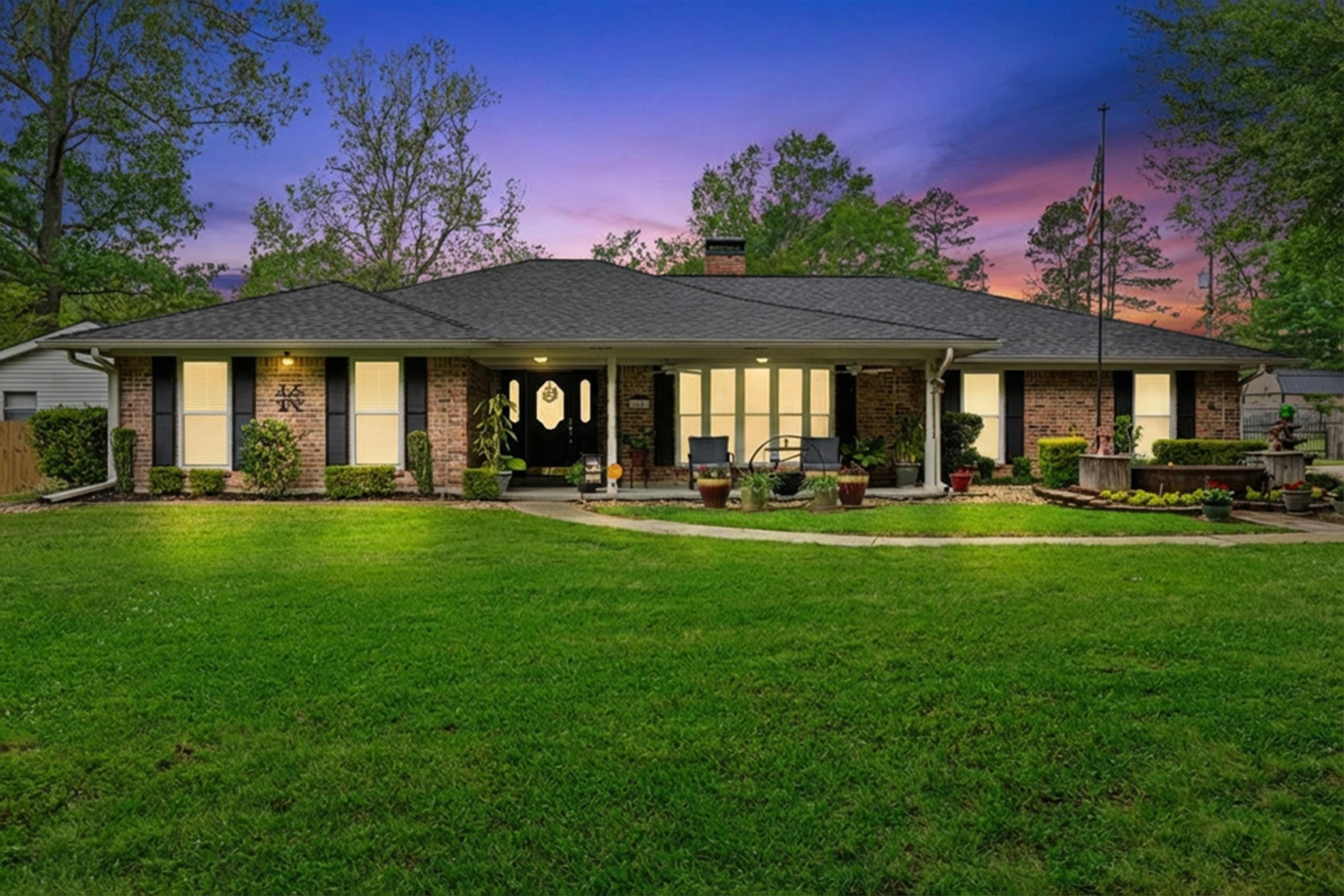 Image 3: Single story home with a chimney, covered porch, a lawn, brick siding, and a shingled roof, Front Of Structure
