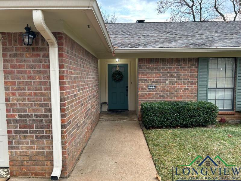 Image 1: View of exterior entry featuring brick siding and a shingled roof, Entry