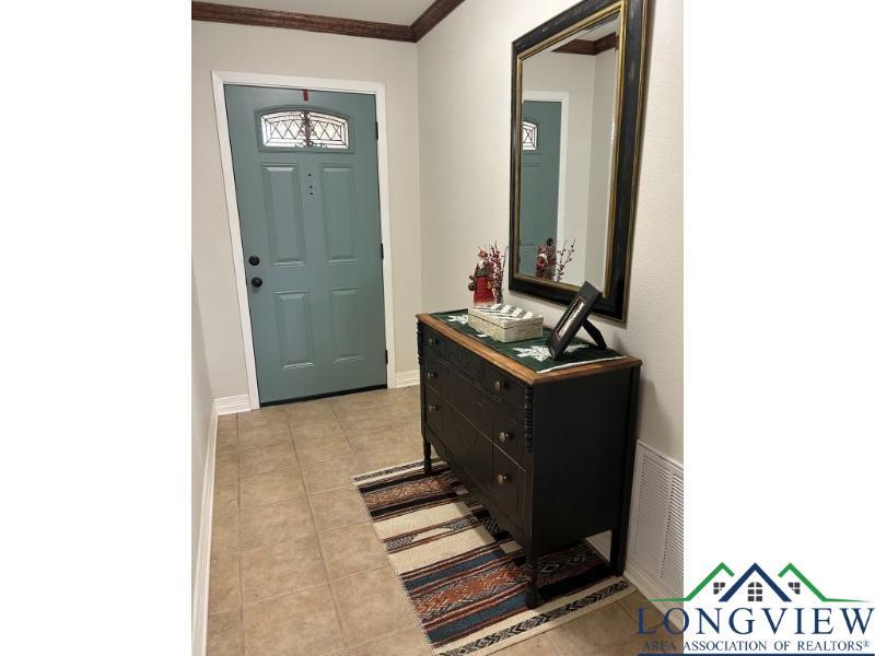 Image 2: Entrance foyer featuring light tile patterned floors and crown molding, Entrance Foyer