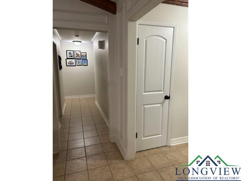 Image 3: Hall with light tile patterned floors and ornamental molding, Hallway