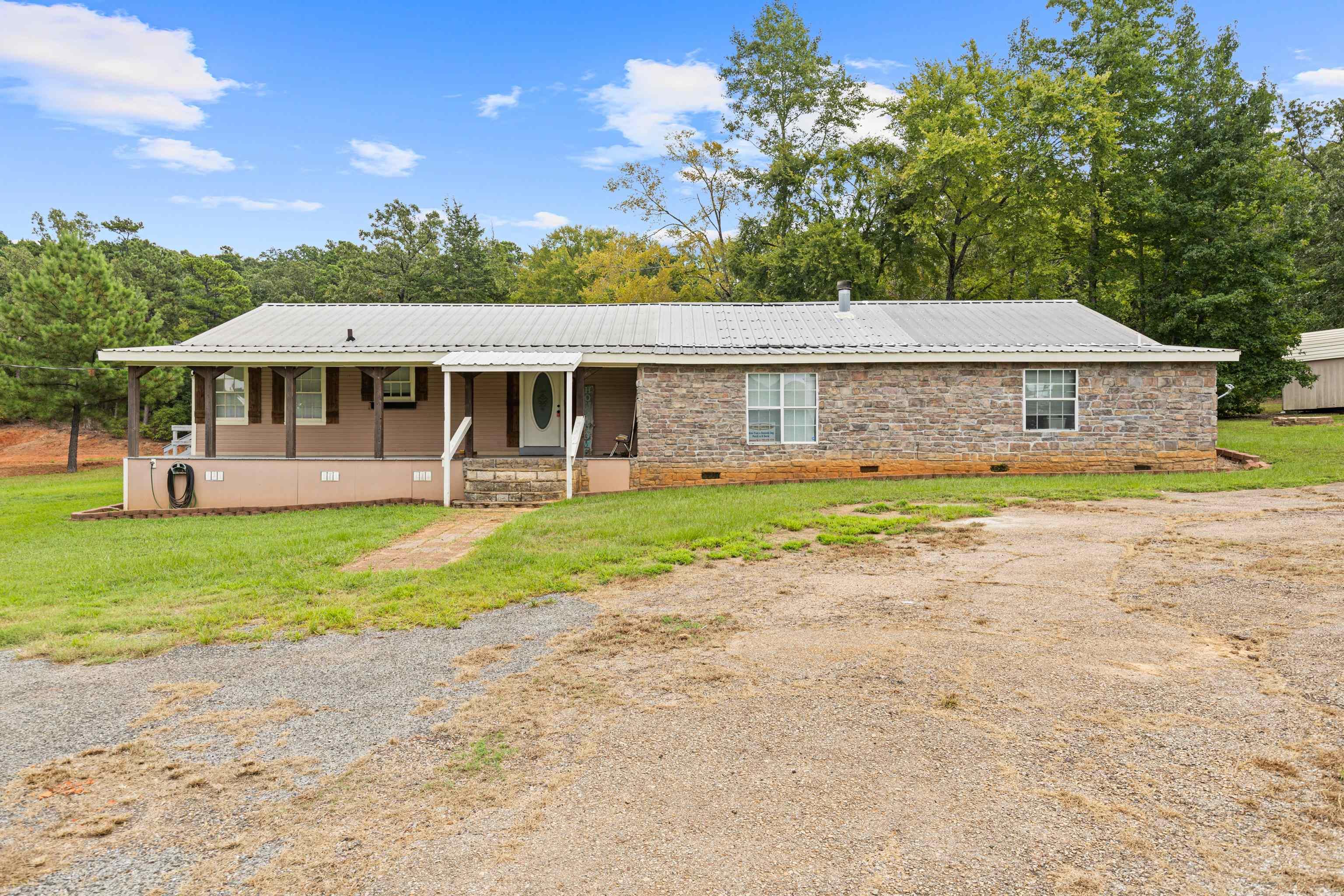 Image 0: View of front of home featuring crawl space, a front lawn, a porch, and a metal roof, Front Of Structure