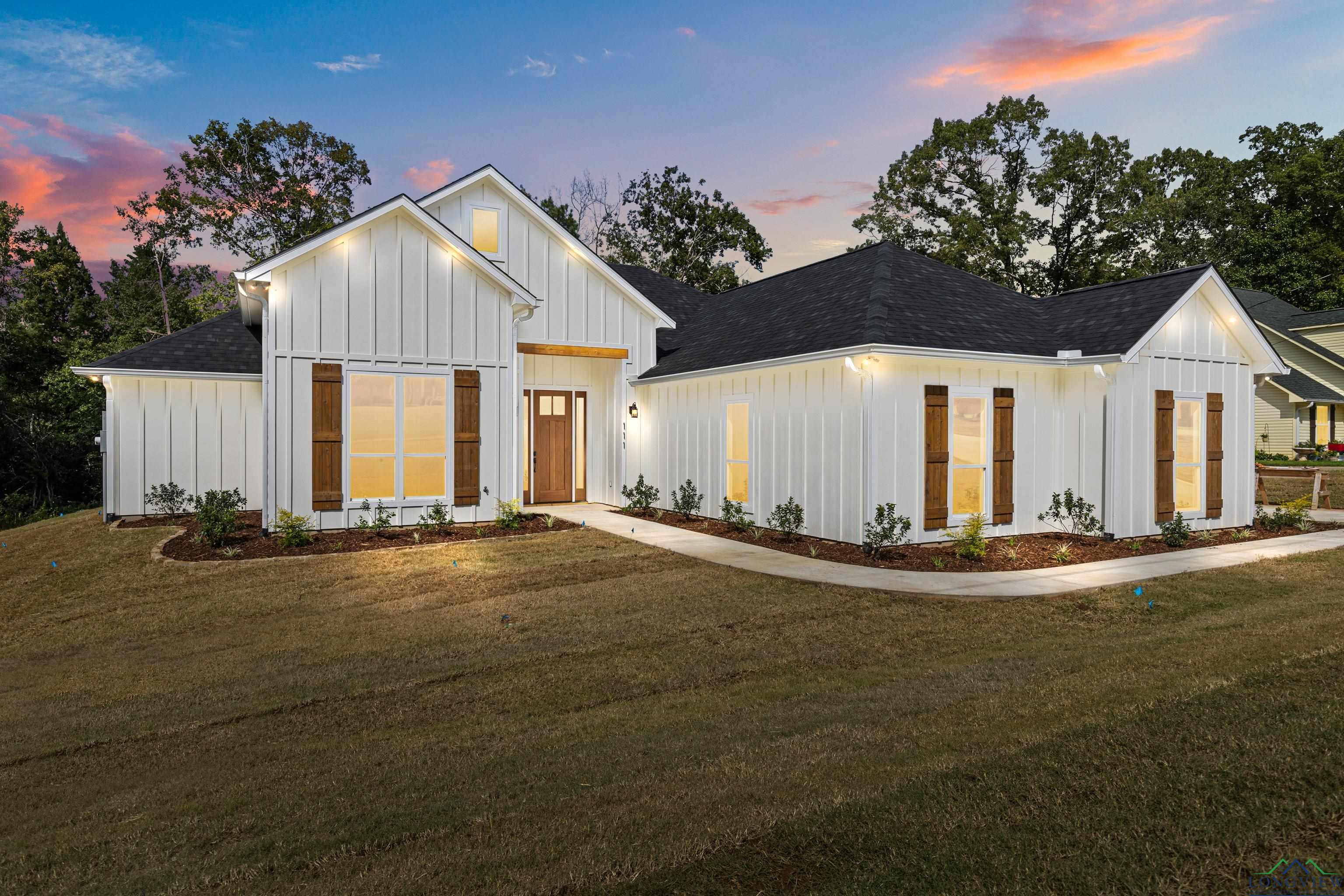 Image 0: Modern inspired farmhouse with board and batten siding, a front yard, and a shingled roof, Front Of Structure