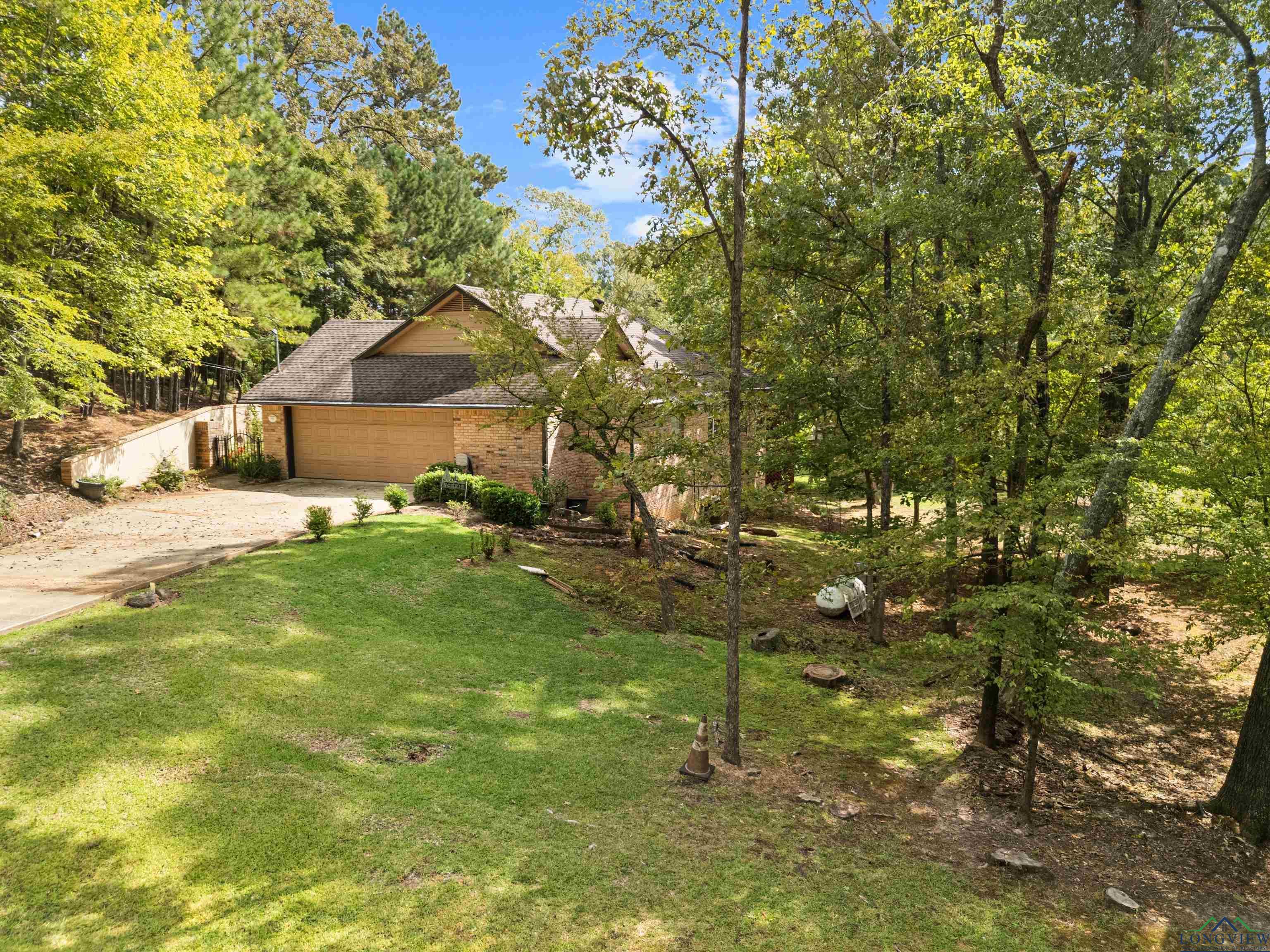 Image 3: View of front of property with brick siding, driveway, an attached garage, and roof with shingles, Front Of Structure