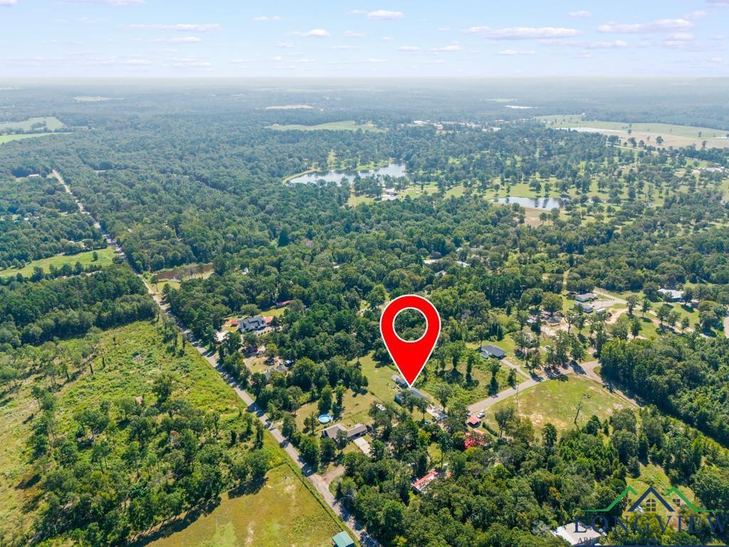 Image 3: View of property location featuring a nearby body of water and a heavily wooded area, Aerial View