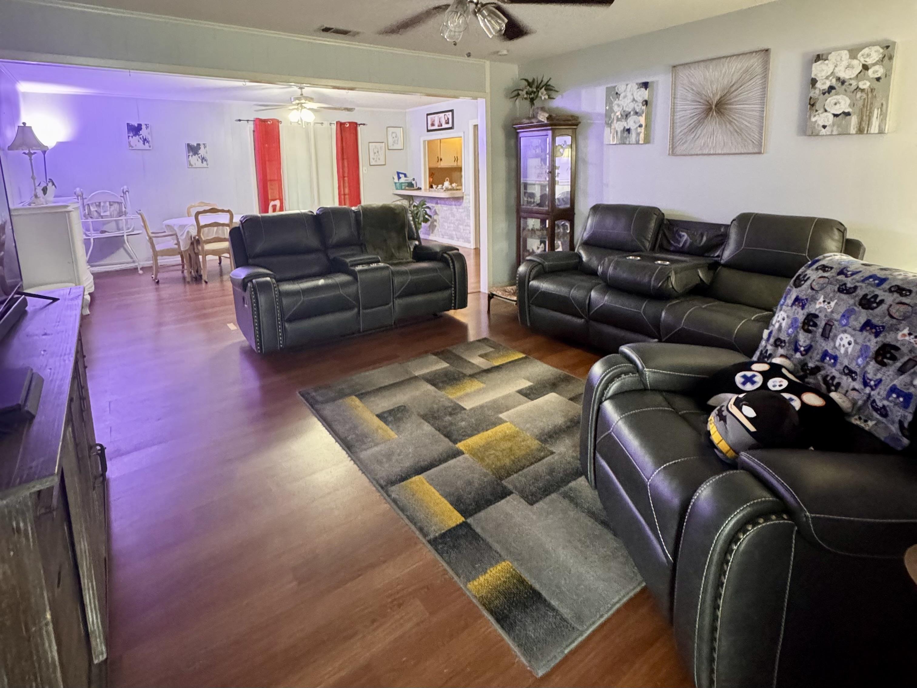 Image 1: Living room featuring dark wood-style flooring and ceiling fan, Living Room