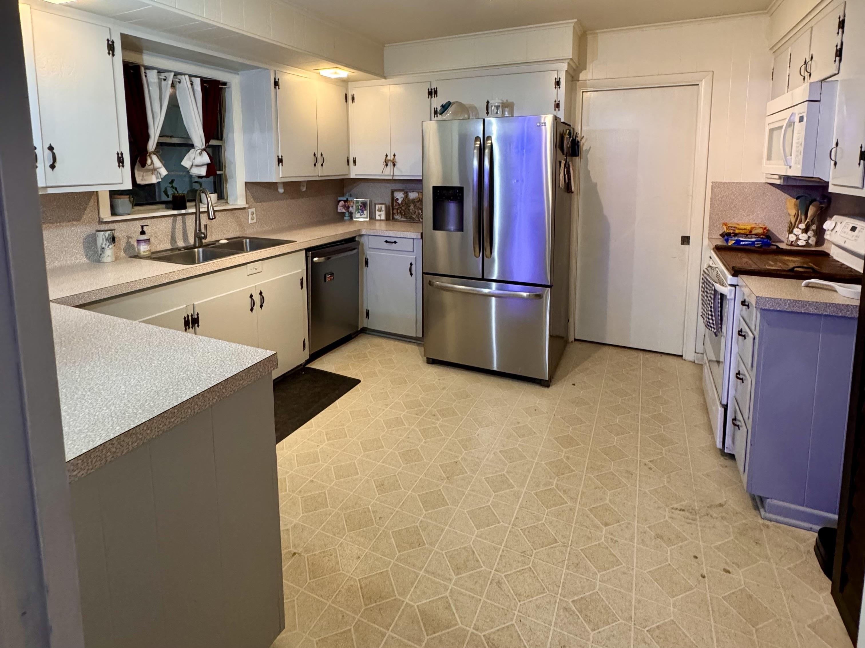 Image 3: Kitchen featuring light flooring, stainless steel appliances, light countertops, and white cabinetry, Kitchen