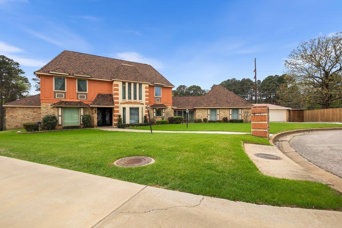 Image 2: View of front of house with a front yard, roof with shingles, and a garage, Front Of Structure