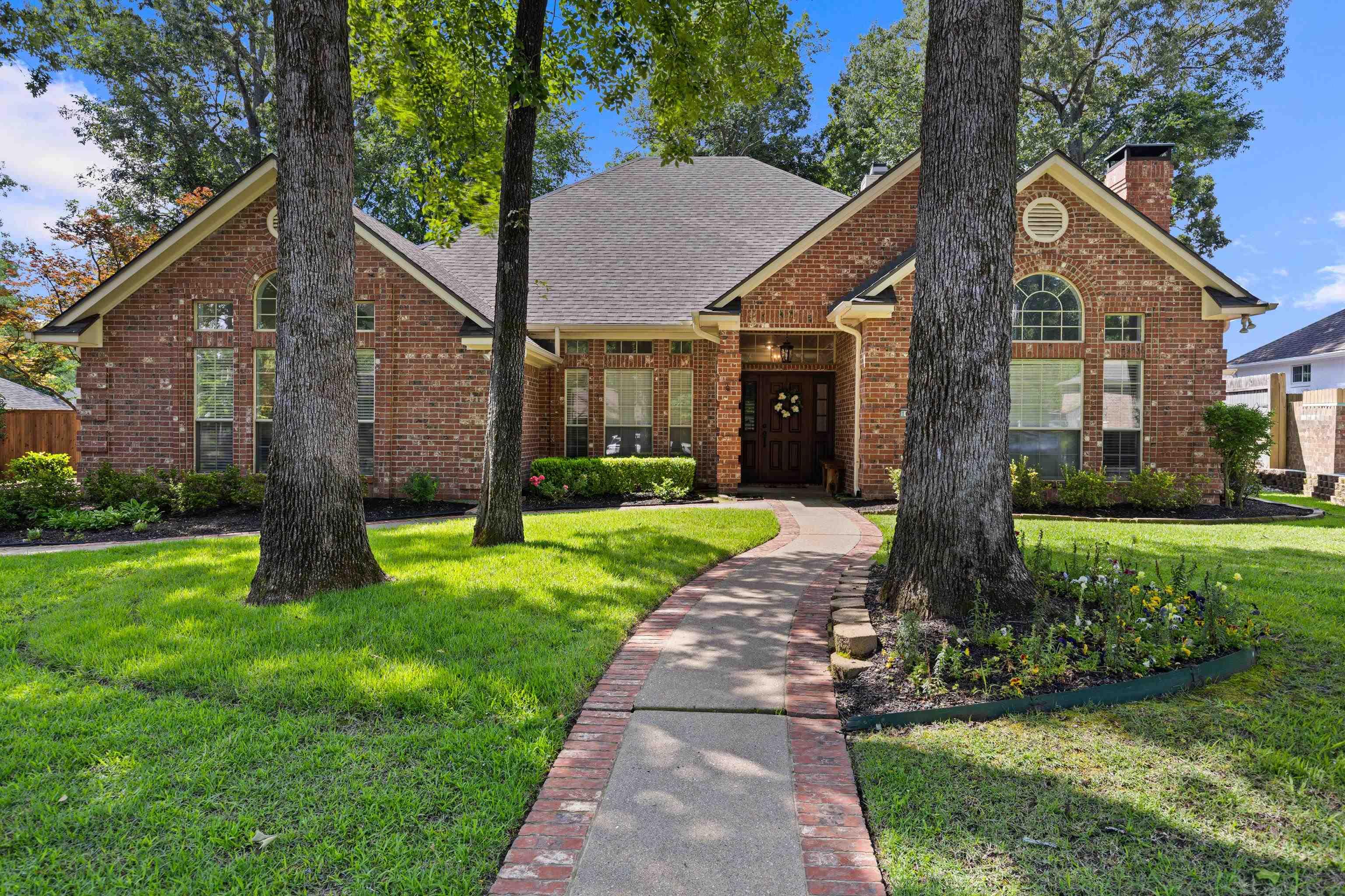 Image 2: Brick exterior with a dark shingle roof and a central entry door, Front Of Structure