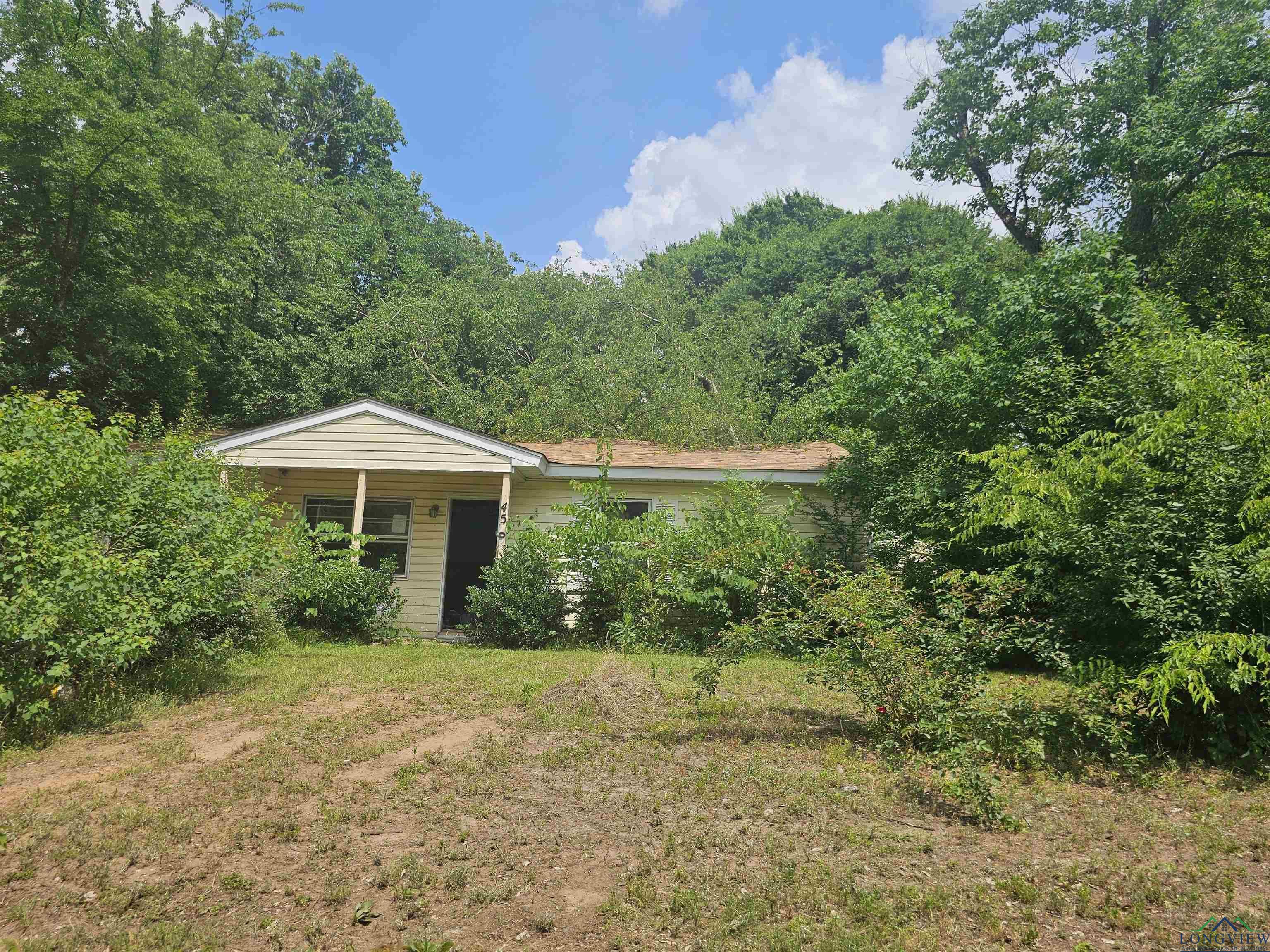Image 0: View of front of house featuring a forest view, Front Of Structure