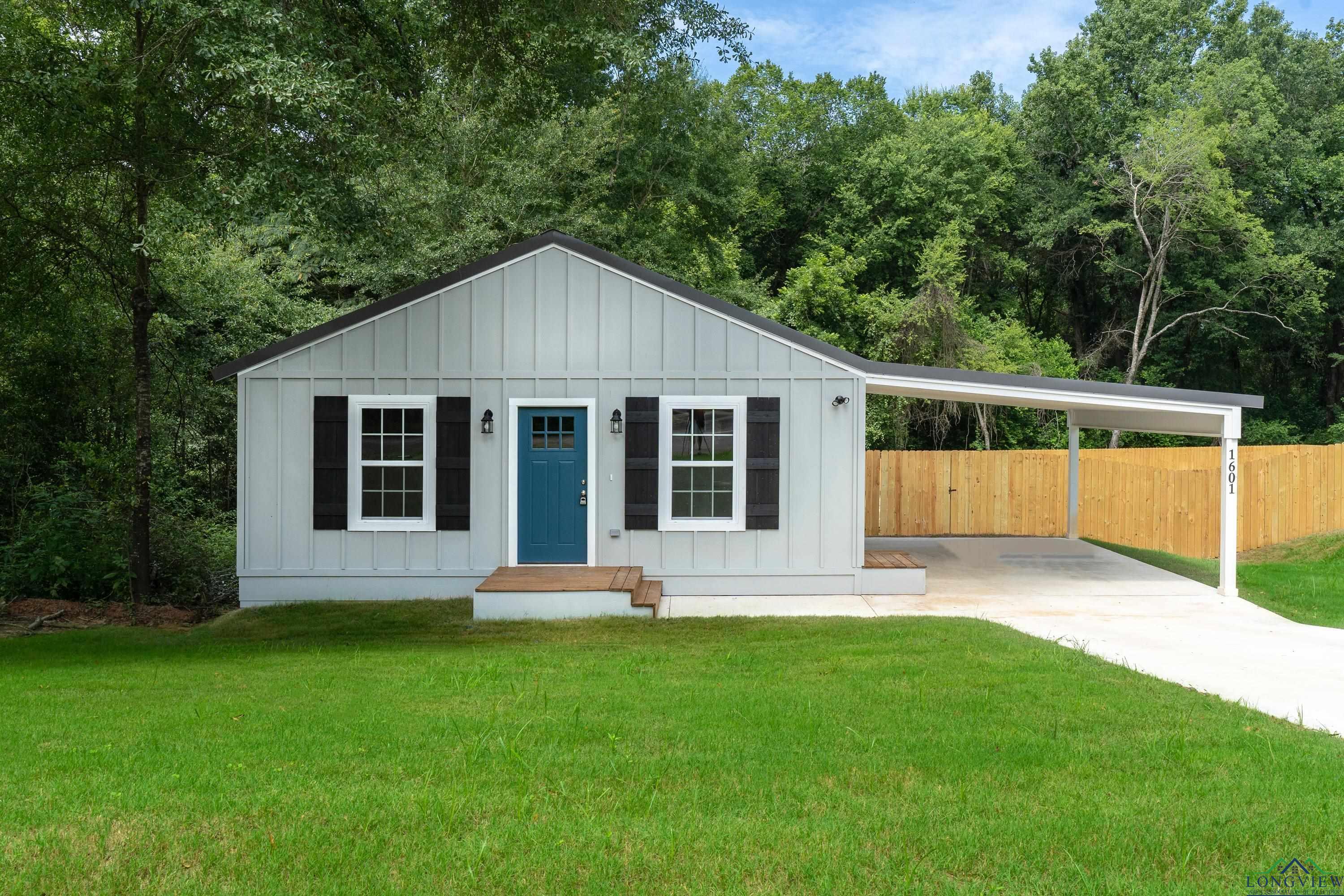 Image 0: View of front of house with board and batten siding and concrete driveway, Front Of Structure