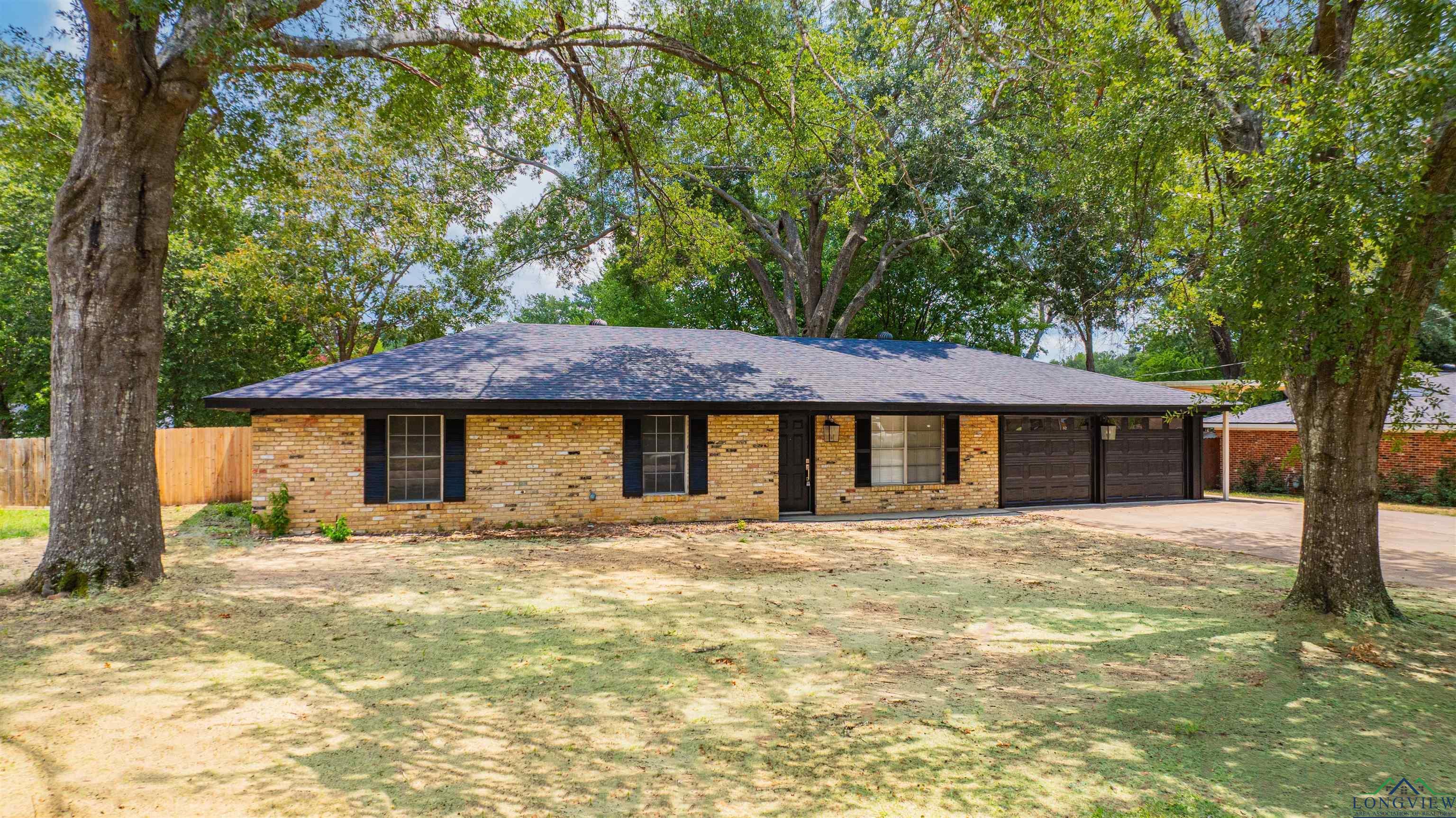 Image 3: Ranch-style home with driveway, brick siding, an attached garage, and a shingled roof, Front Of Structure