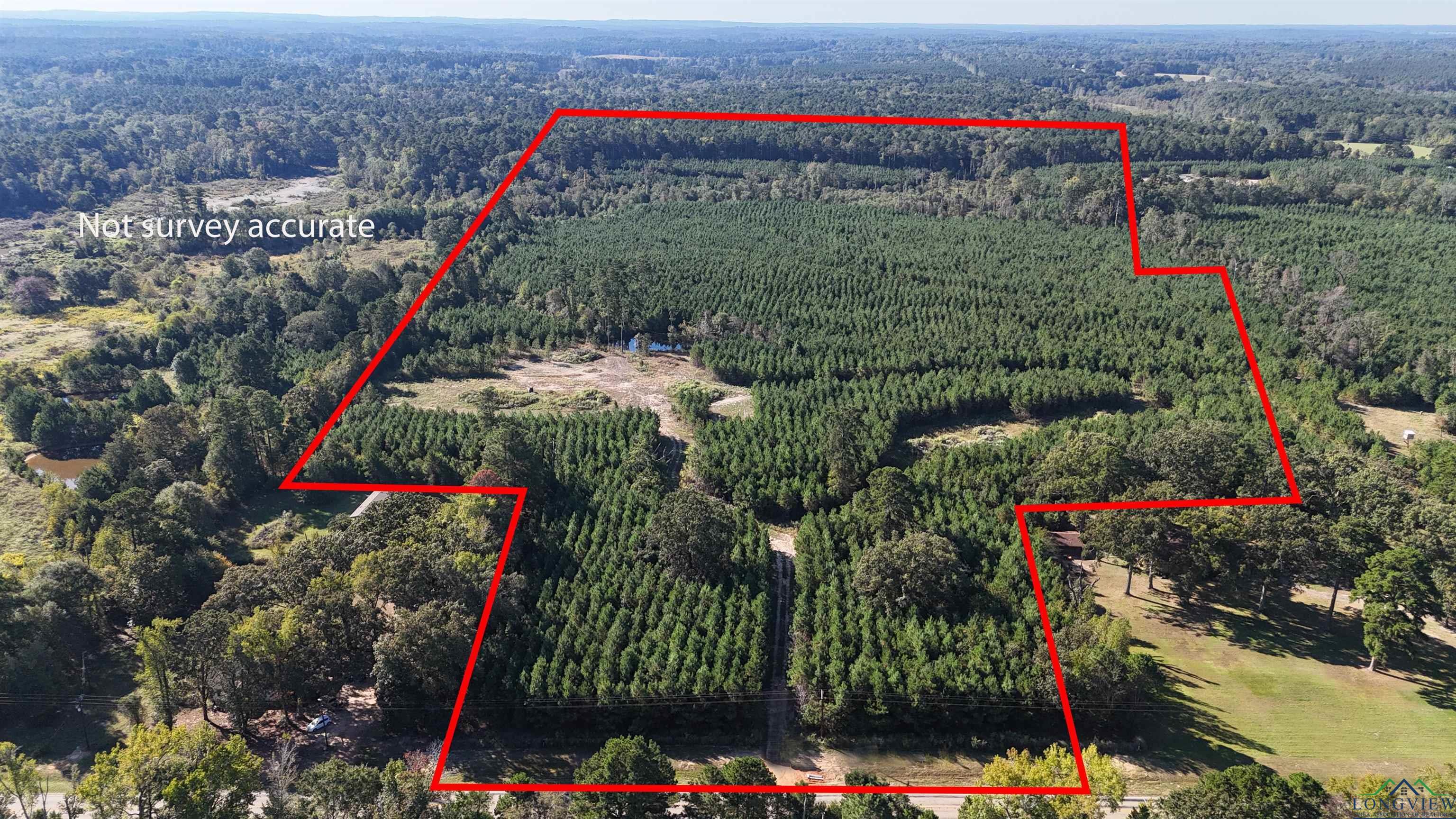 Image 0: Aerial view of property and surrounding area with a forest and property parcel outlined, Aerial View