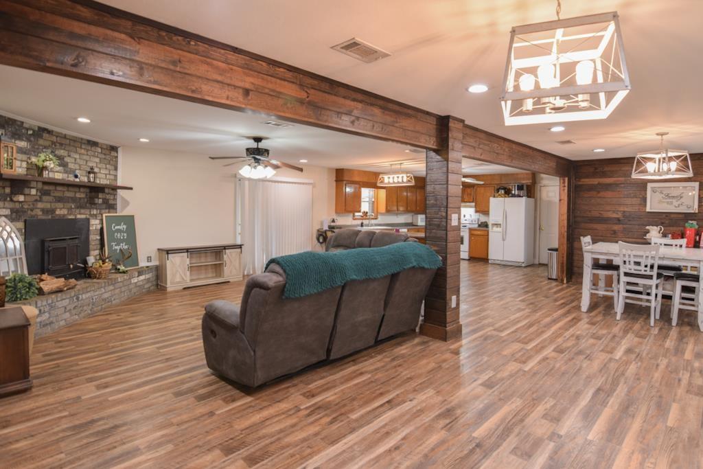 Image 3: Living area with a ceiling fan, wood walls, wood finished floors, a chandelier, and recessed lighting, Living Room