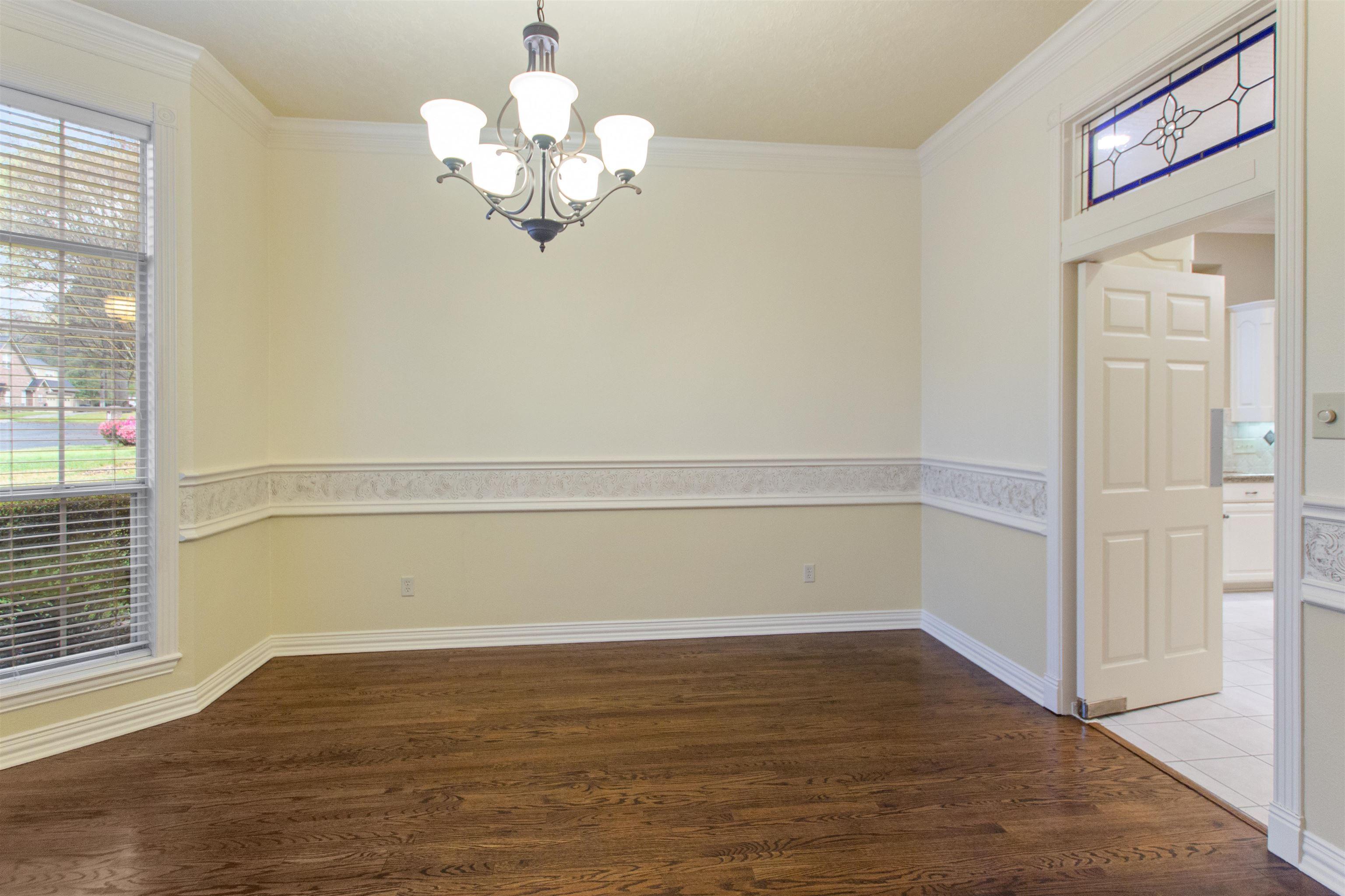 Image 2: Unfurnished dining area featuring dark wood-style flooring, hanging lights, and crown molding, Dining Area