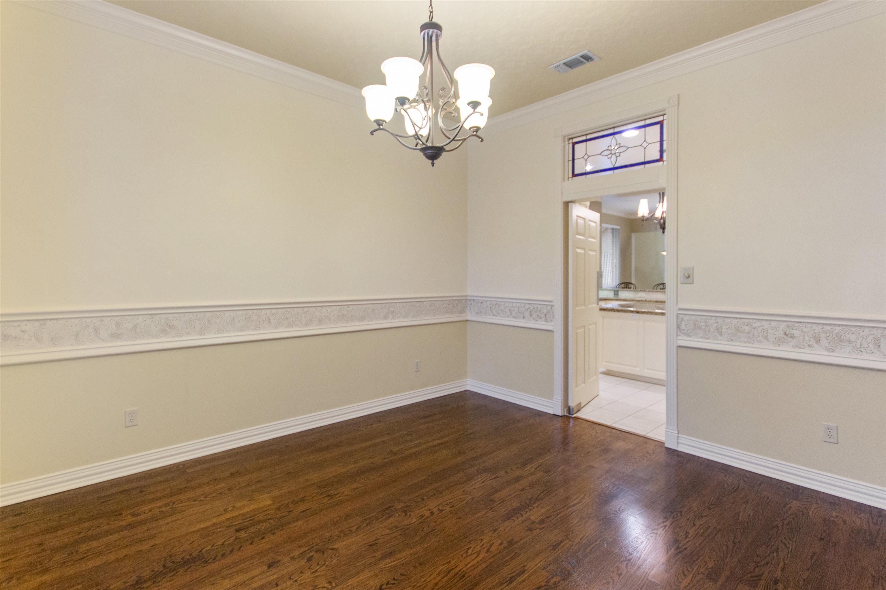 Image 3: Empty room with suspended lighting, crown molding, and dark wood-type flooring, Other