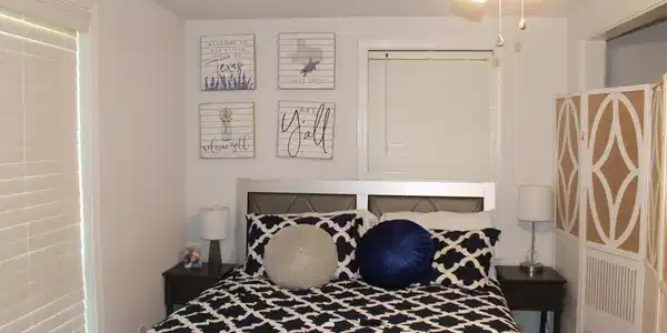 Image 2: Bedroom with a ceiling fan, a window featuring horizontal blinds, and an upholstered headboard, Bedroom