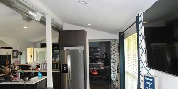 Image 3: Open-concept kitchen area featuring wood-finish flooring, vaulted ceilings with recessed lighting, and exposed spiral ductwork, Kitchen