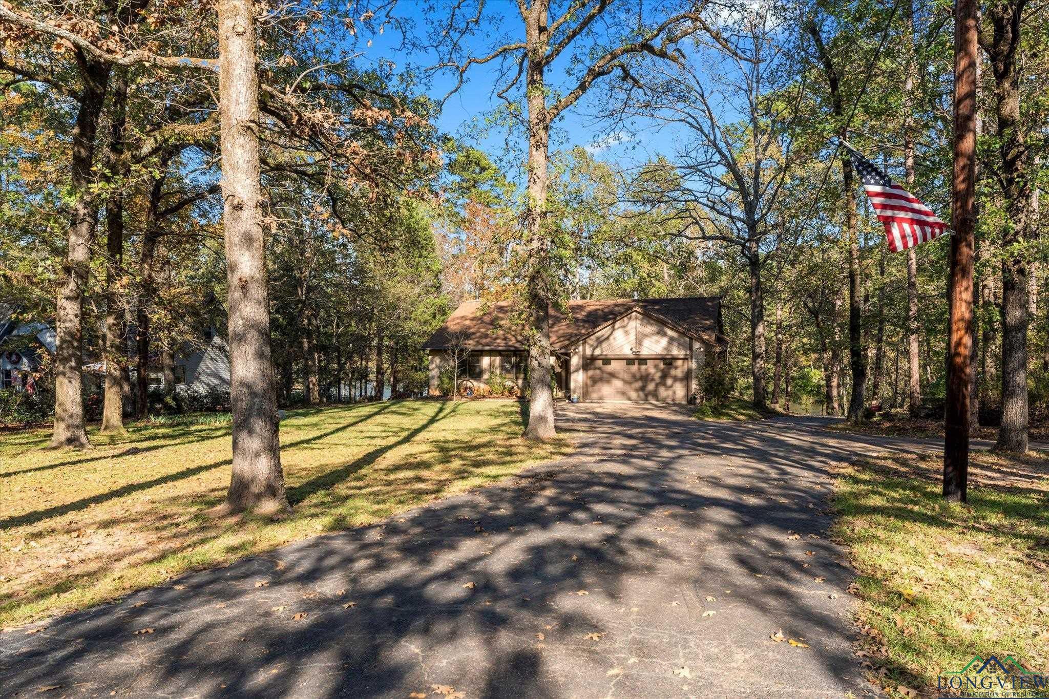 Image 1: Exterior space with aphalt driveway, a detached garage, and a front yard, Front Of Structure