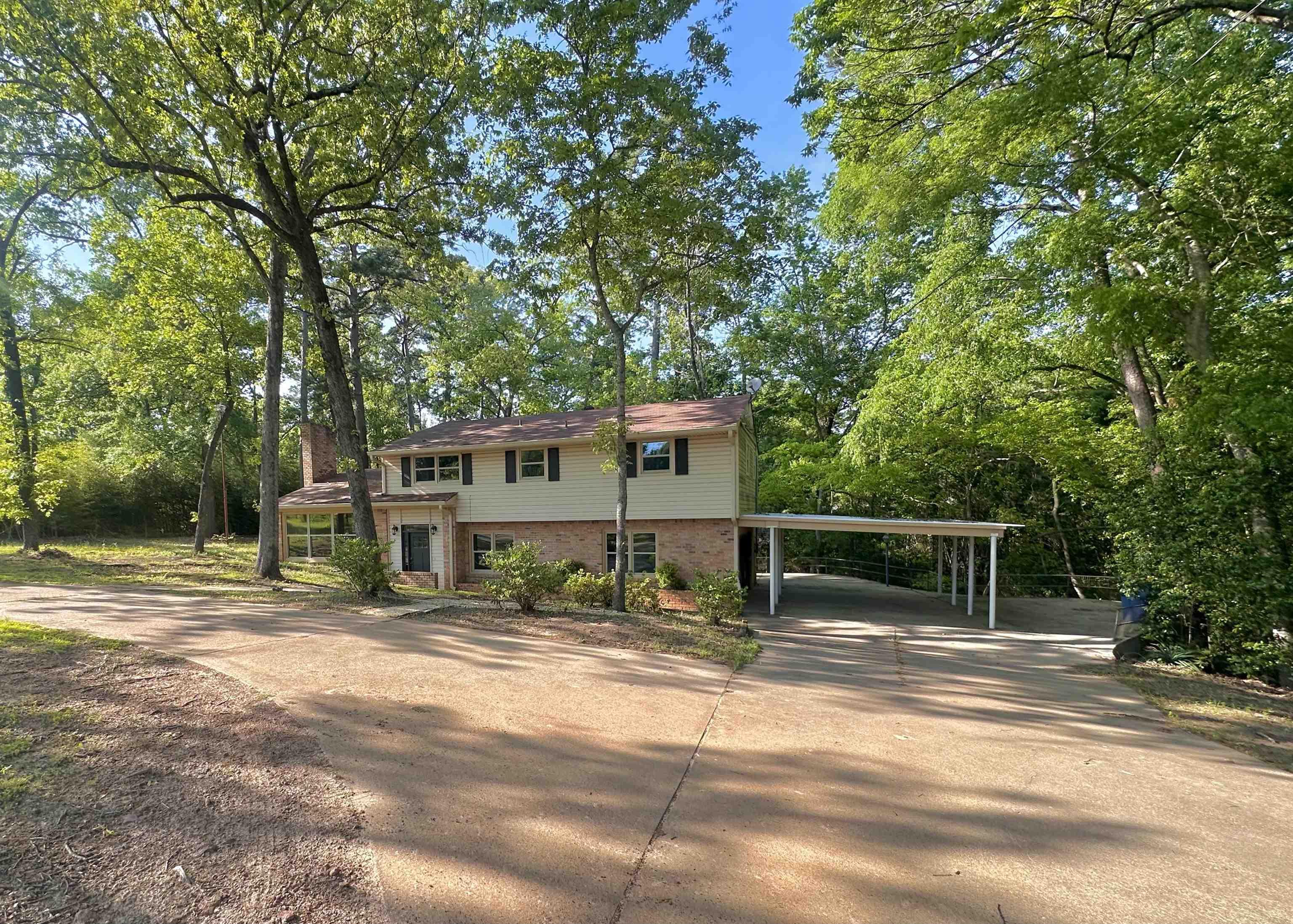 Image 0: View of front of home featuring brick siding, driveway, and a carport, Front Of Structure