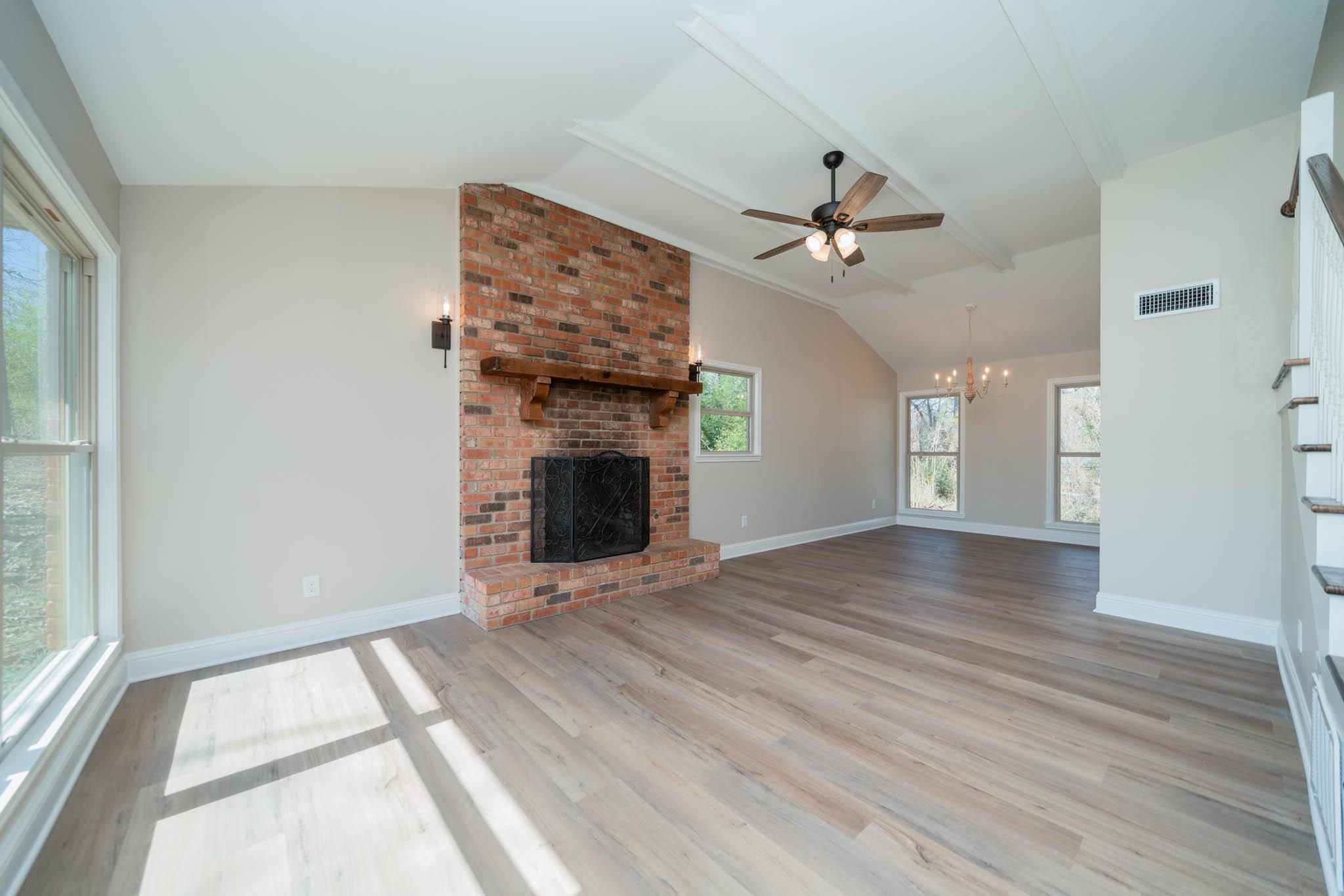 Image 2: Unfurnished living room with a fireplace, ceiling fan, light wood-style flooring, and a chandelier, Living Room