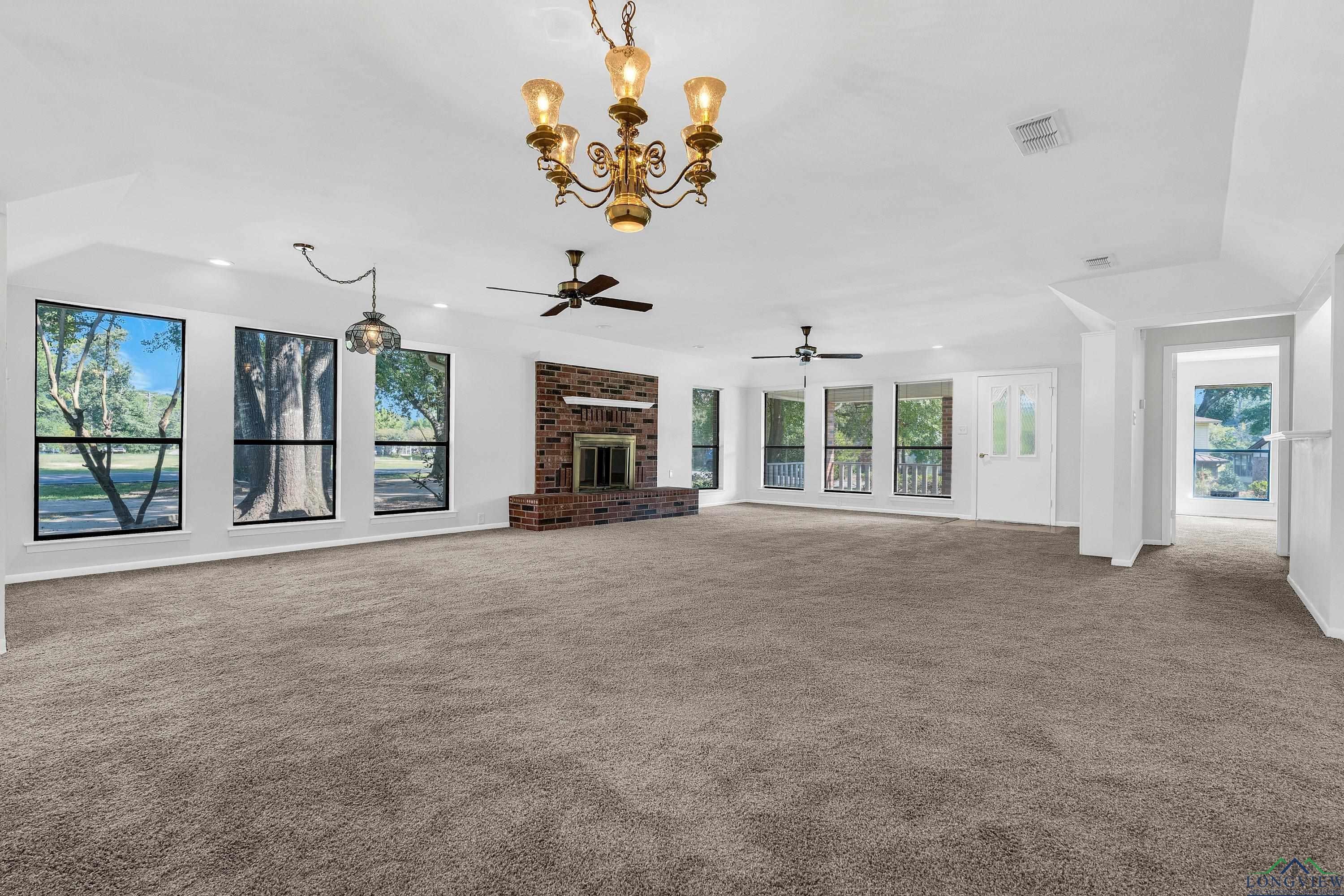 Image 2: Unfurnished living room featuring healthy amount of natural light, carpet floors, and a chandelier, Living Room