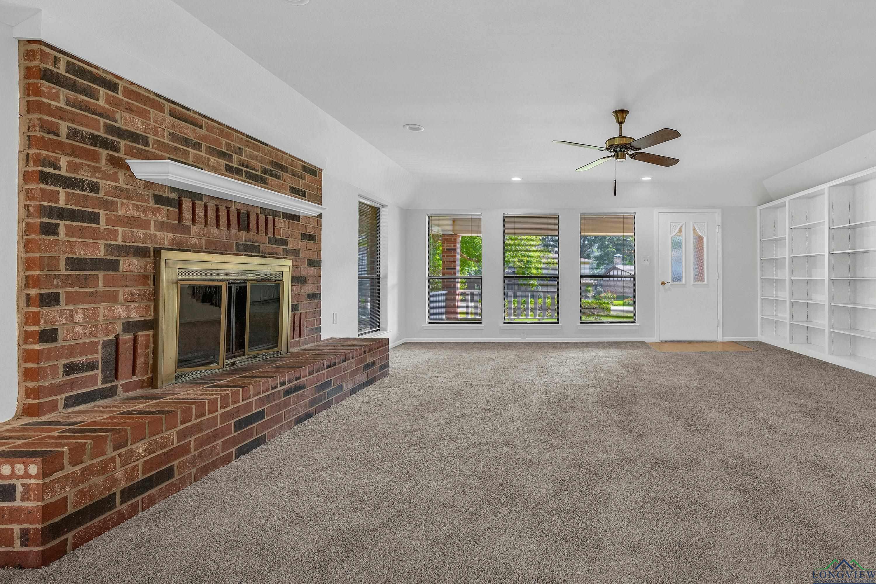 Image 3: Unfurnished living room with a brick fireplace, carpet, recessed lighting, a ceiling fan, and built in features, Living Room