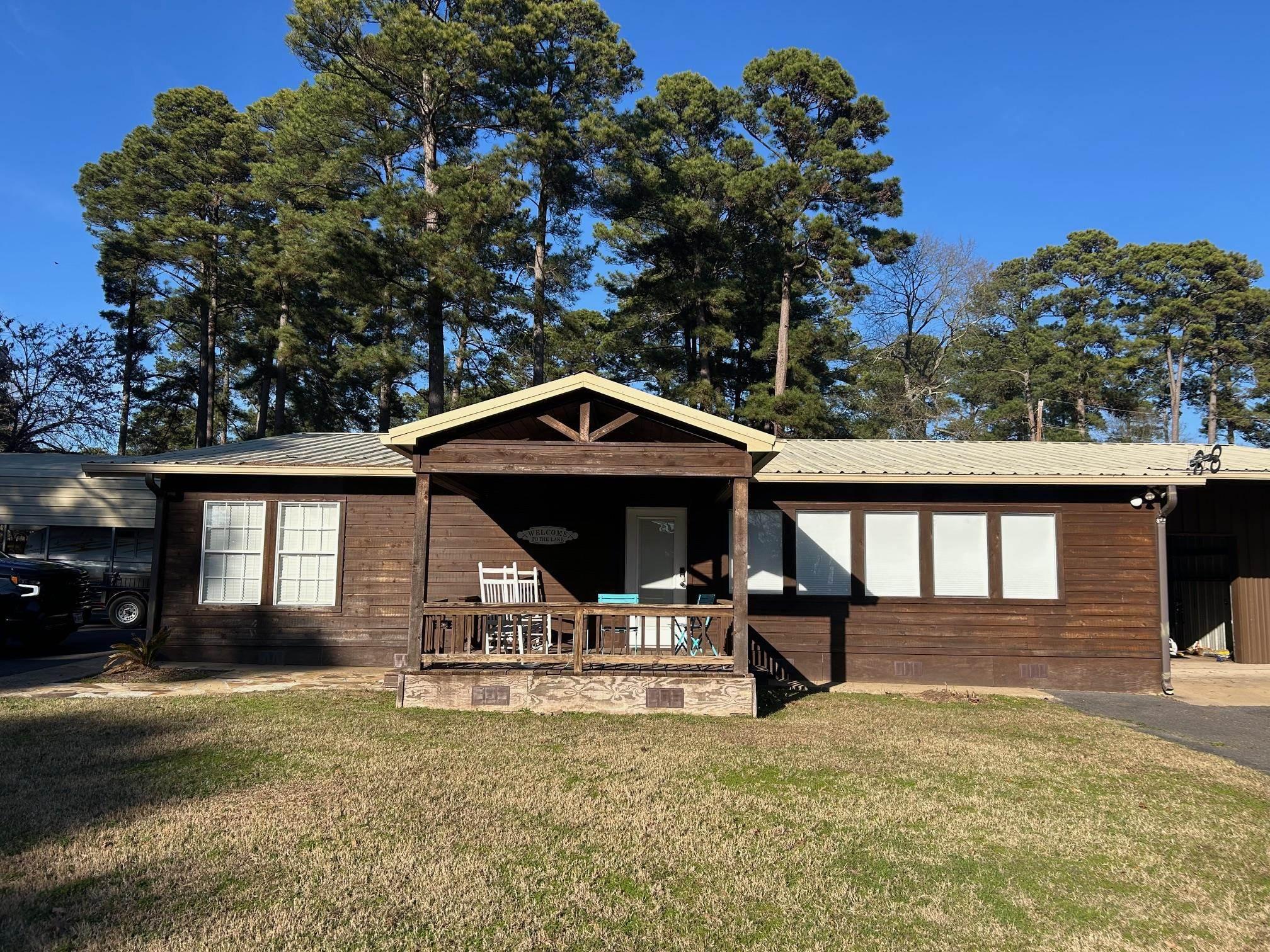 Image 3: Ranch-style house featuring a metal roof and a front yard, Front Of Structure