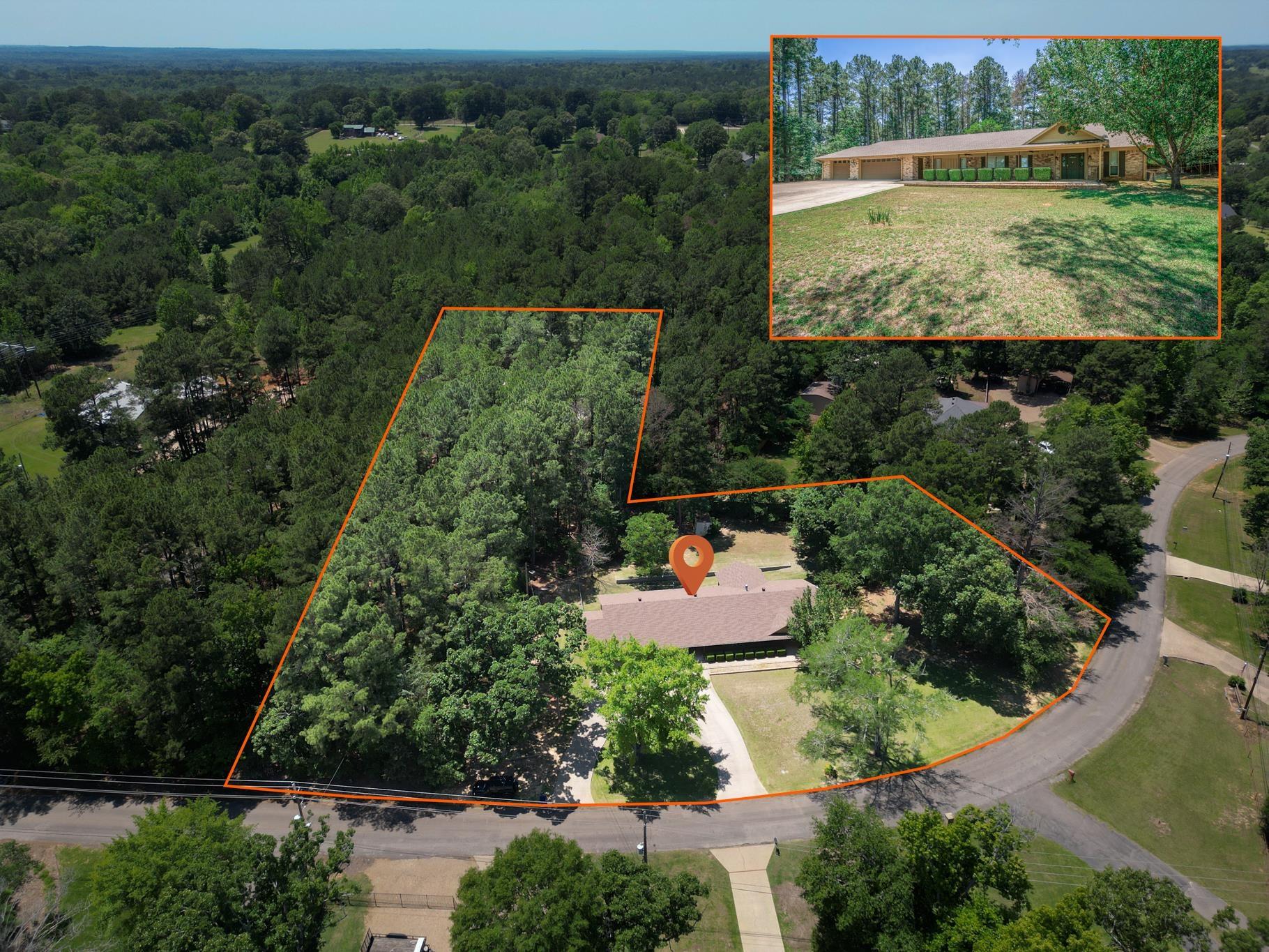 Image 2: Sprawling property featuring a single-story residence with a multi-car garage, extensive tree coverage, and a circular driveway, Aerial View