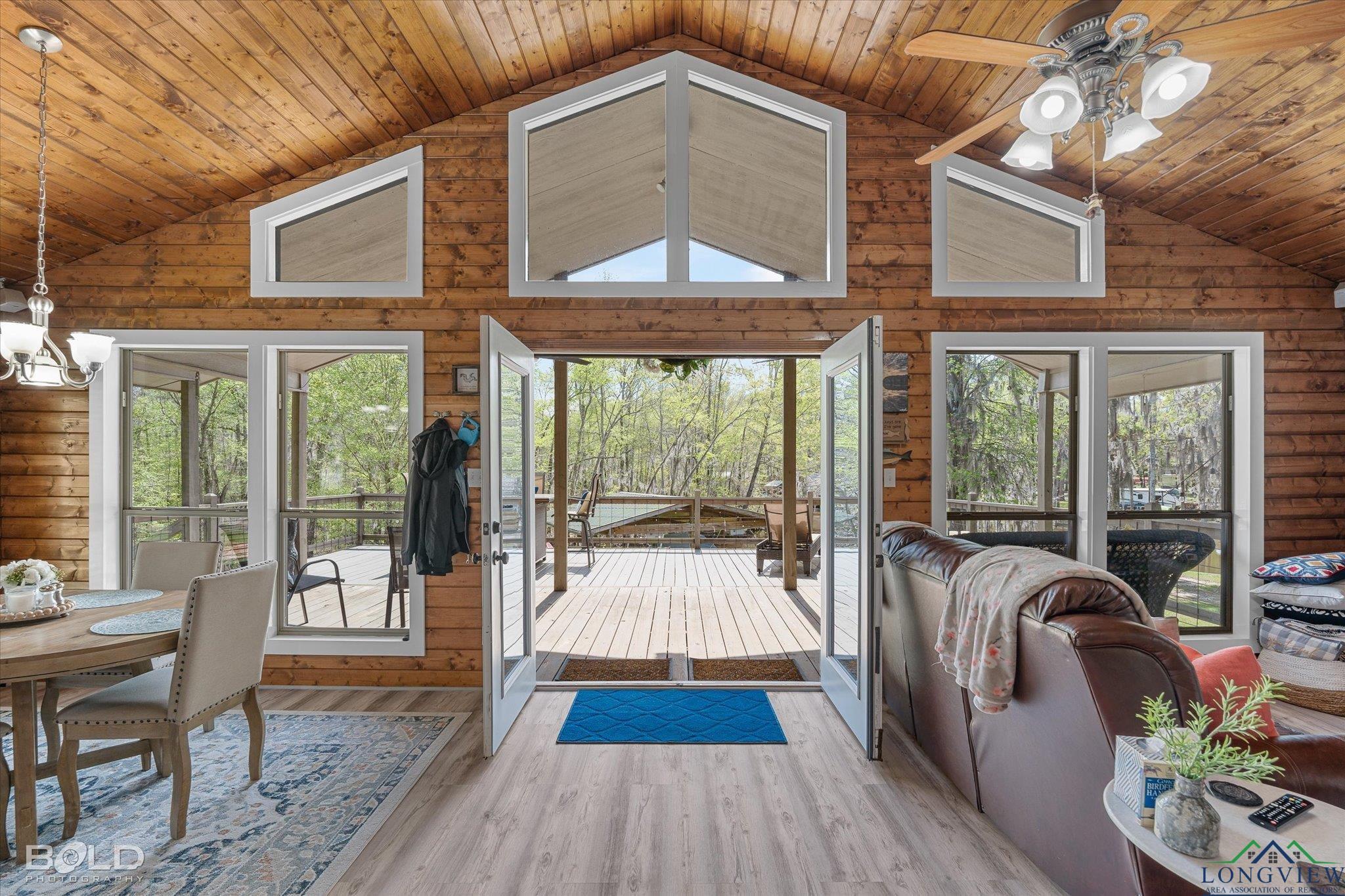 Image 1: Living room with wood ceiling, light wood-type flooring, and a healthy amount of sunlight, Living Room
