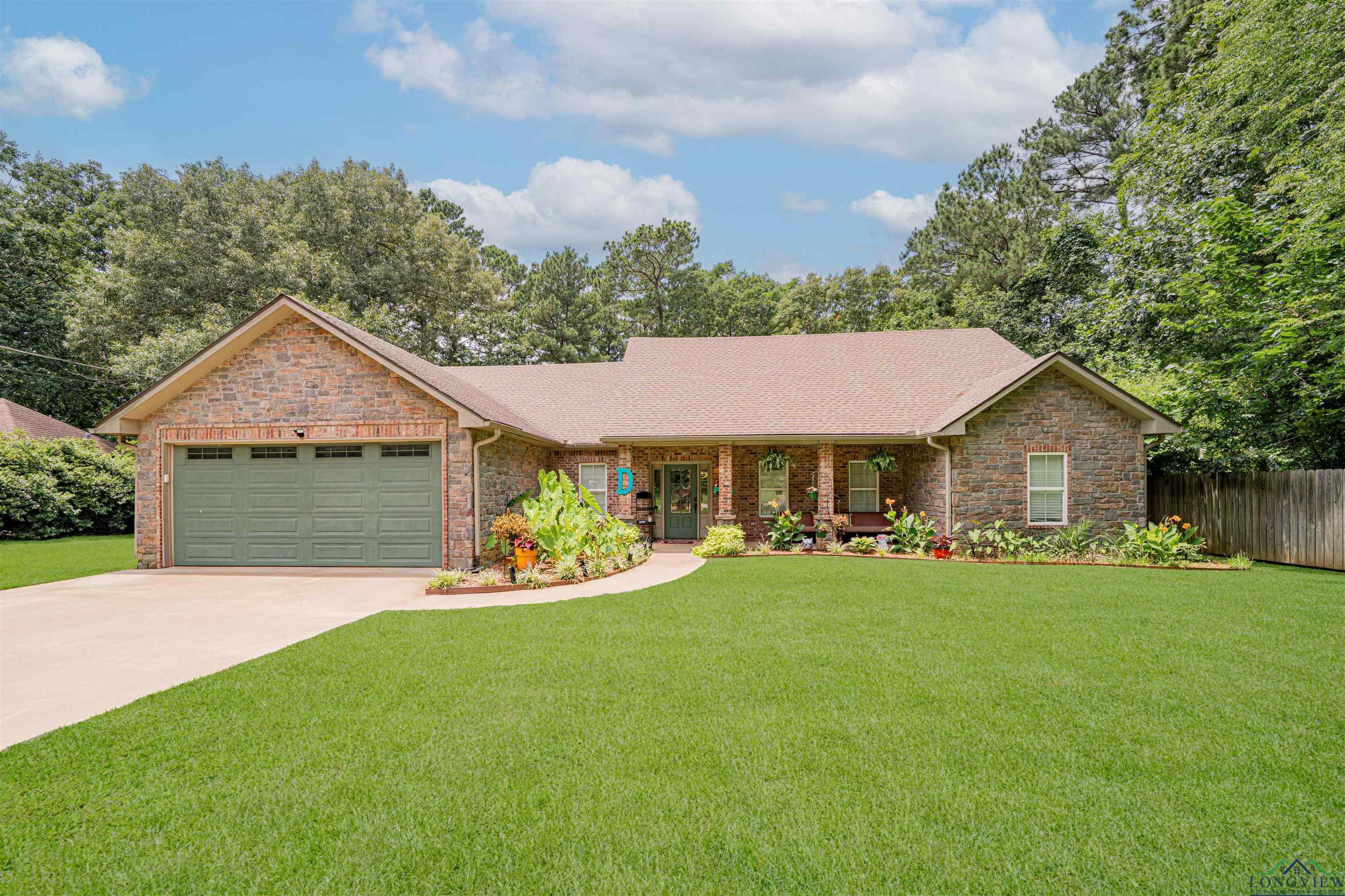 Image 0: Ranch-style house featuring an attached garage, driveway, a shingled roof, covered porch, and brick siding, Front Of Structure