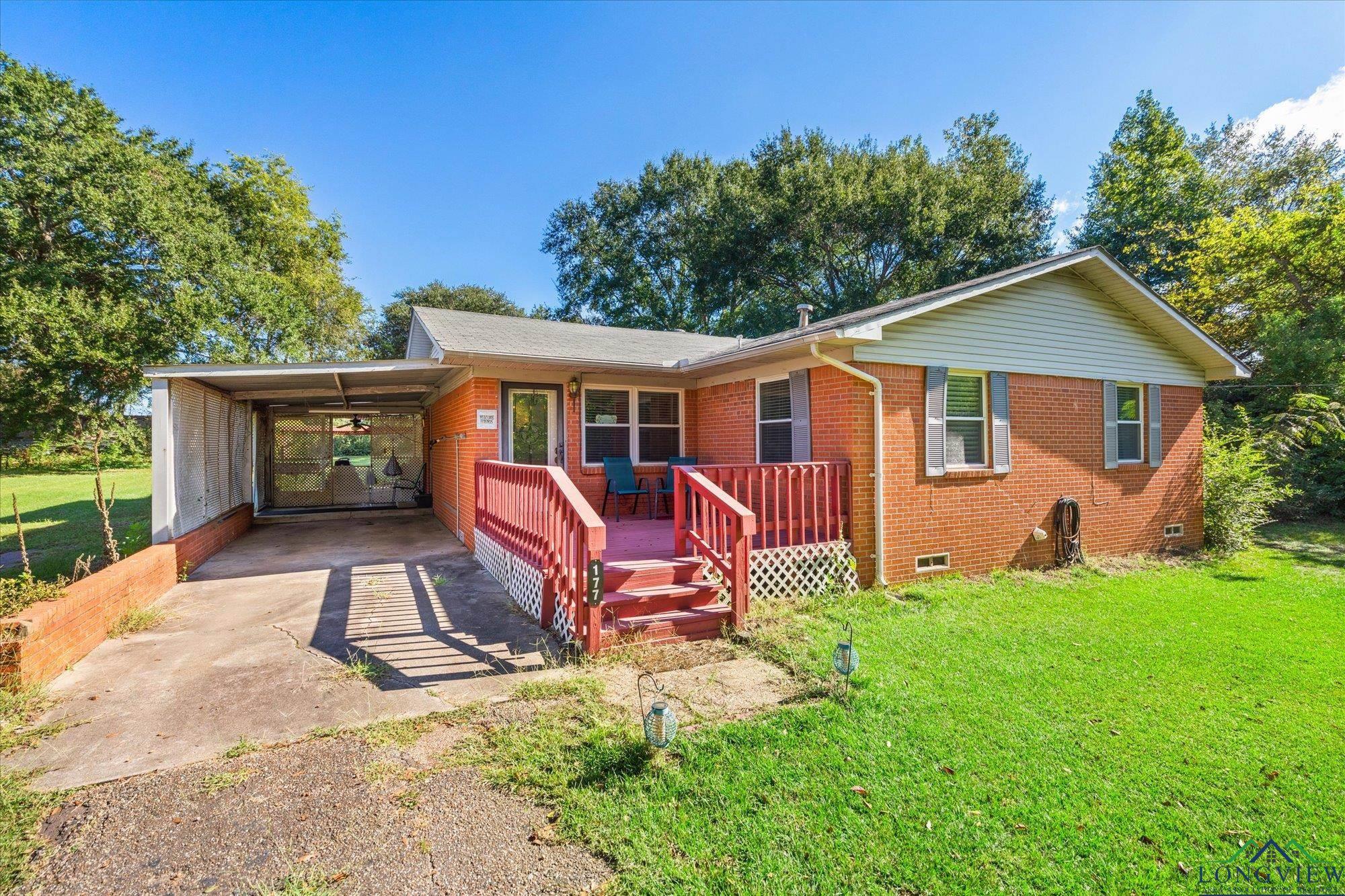 Image 0: Rear view of house featuring a yard, crawl space, brick siding, a deck, and a carport, Back Of Structure