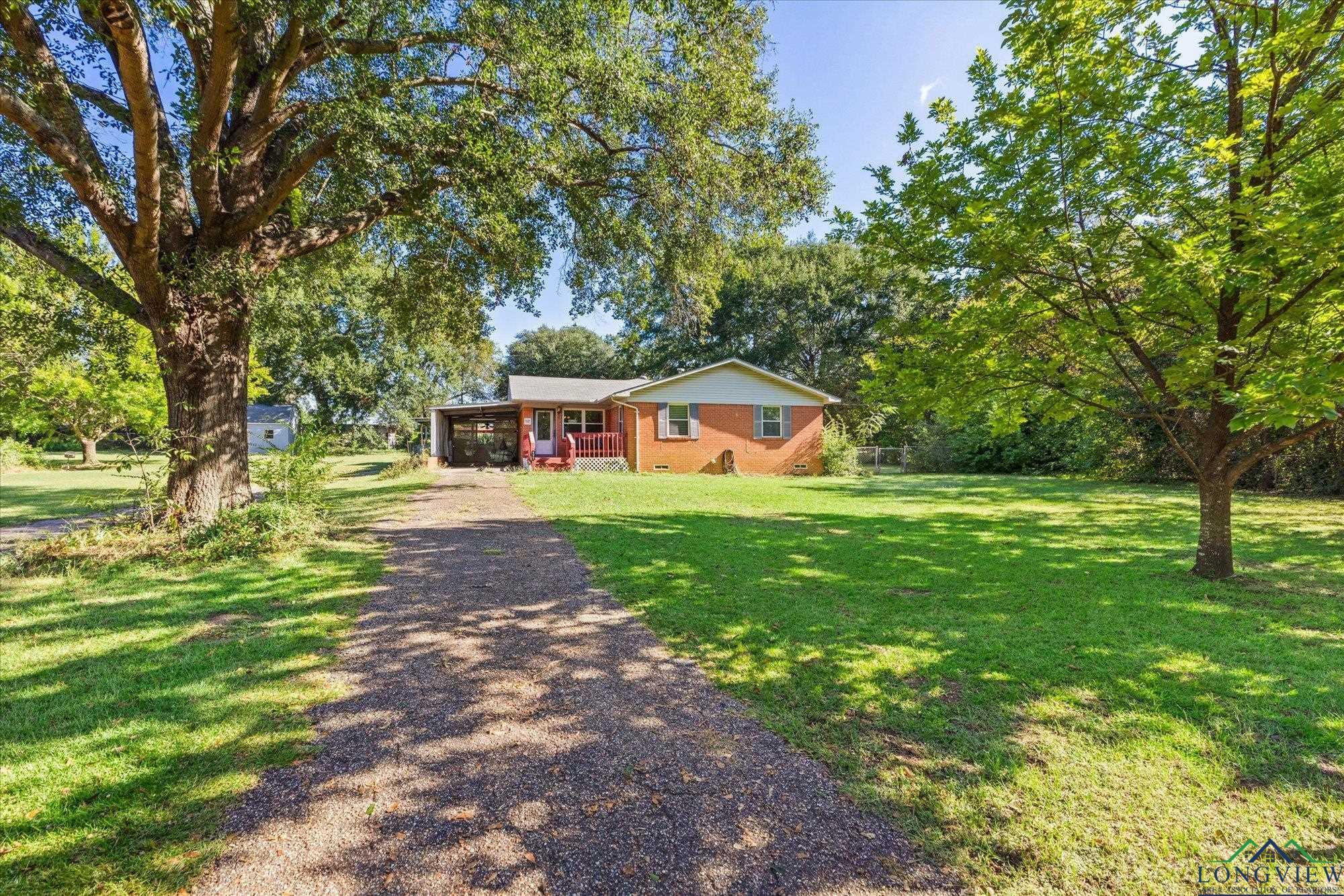 Image 1: Ranch-style house with driveway, a front lawn, and brick siding, Front Of Structure