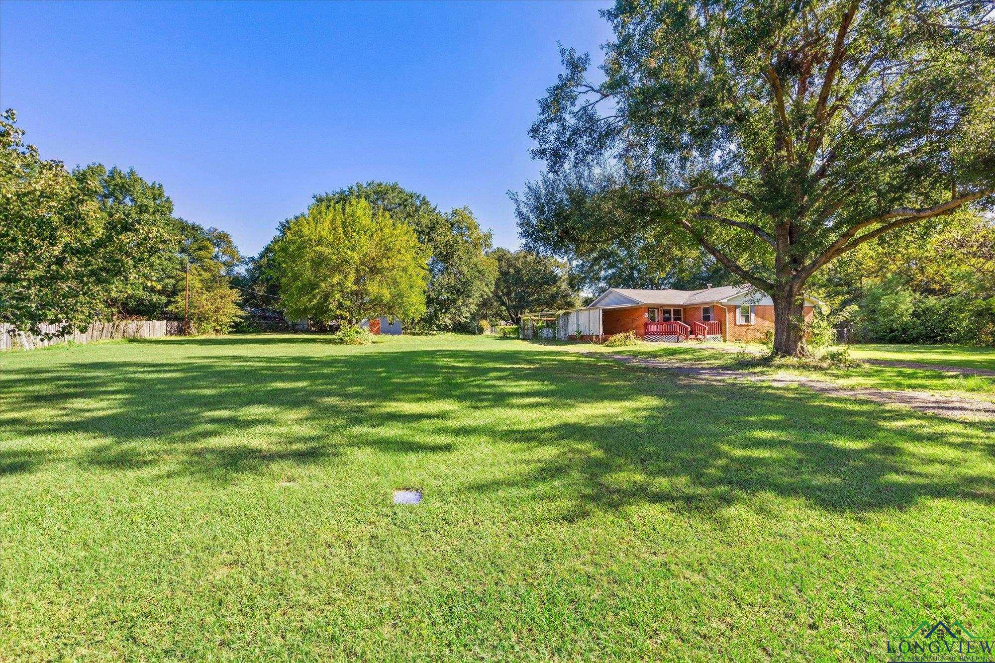 Image 3: View of grassy yard with a wooden deck, Yard