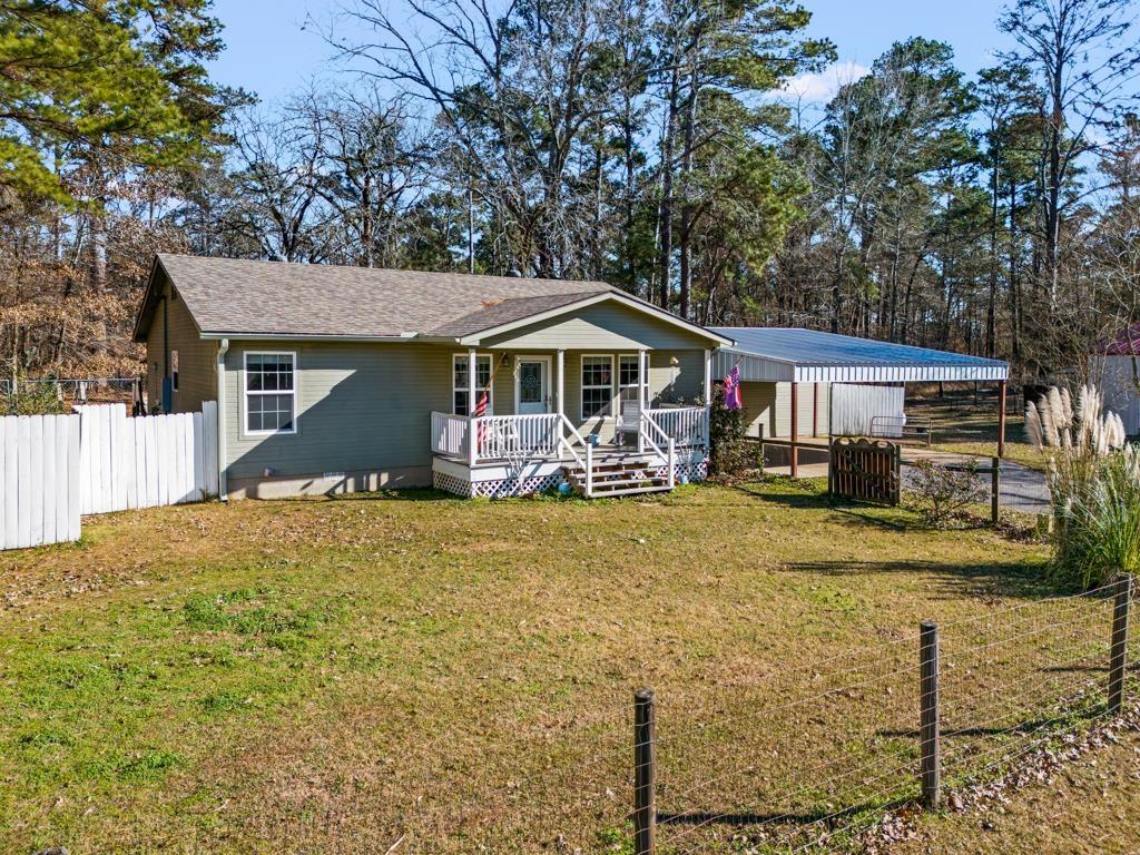 Image 1: View of front of home featuring a porch and a carport, Front Of Structure